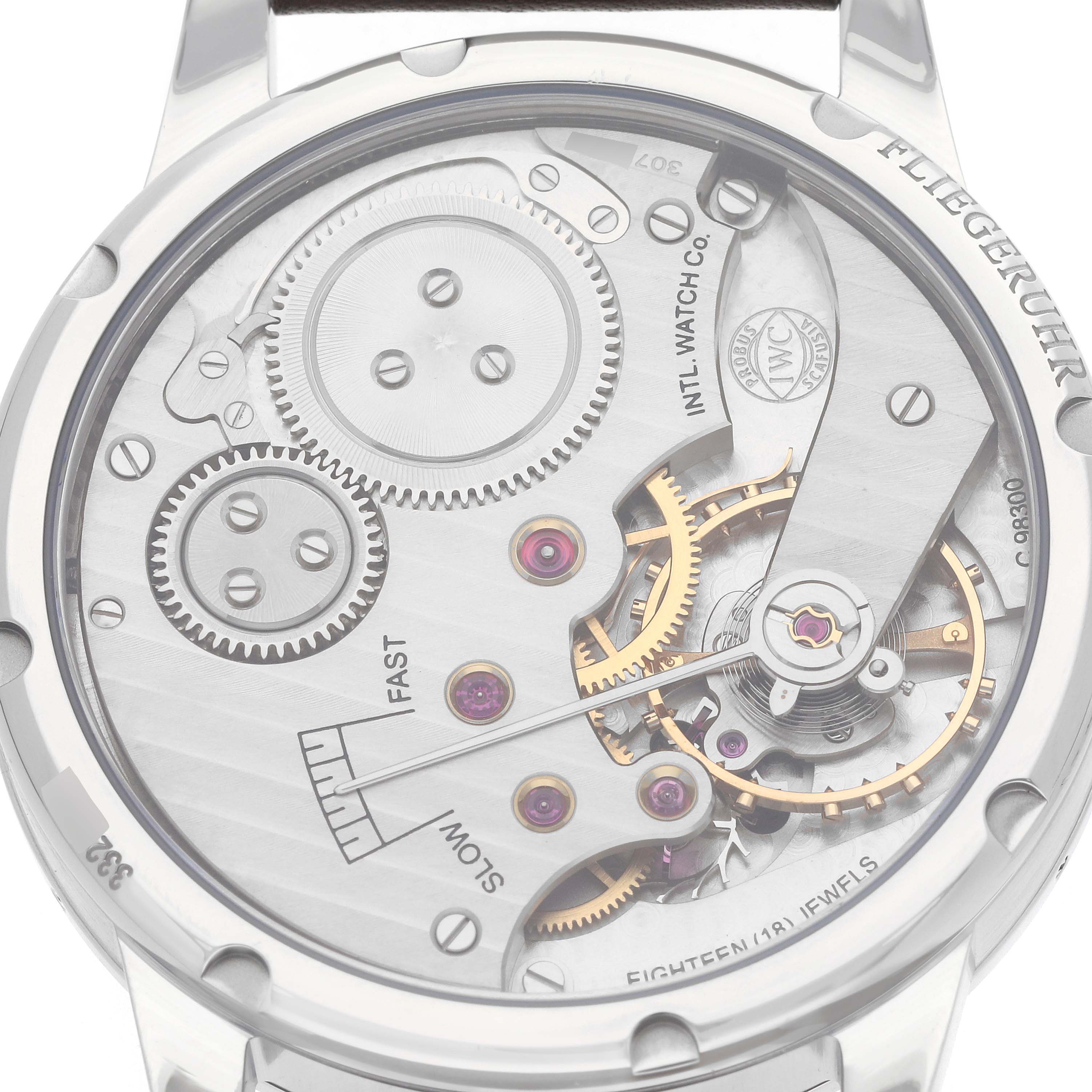 The IWC Pilot IW325401 Men
s Platinum Black Dial model is shown from the rear, highlighting its intricate movement and gears.