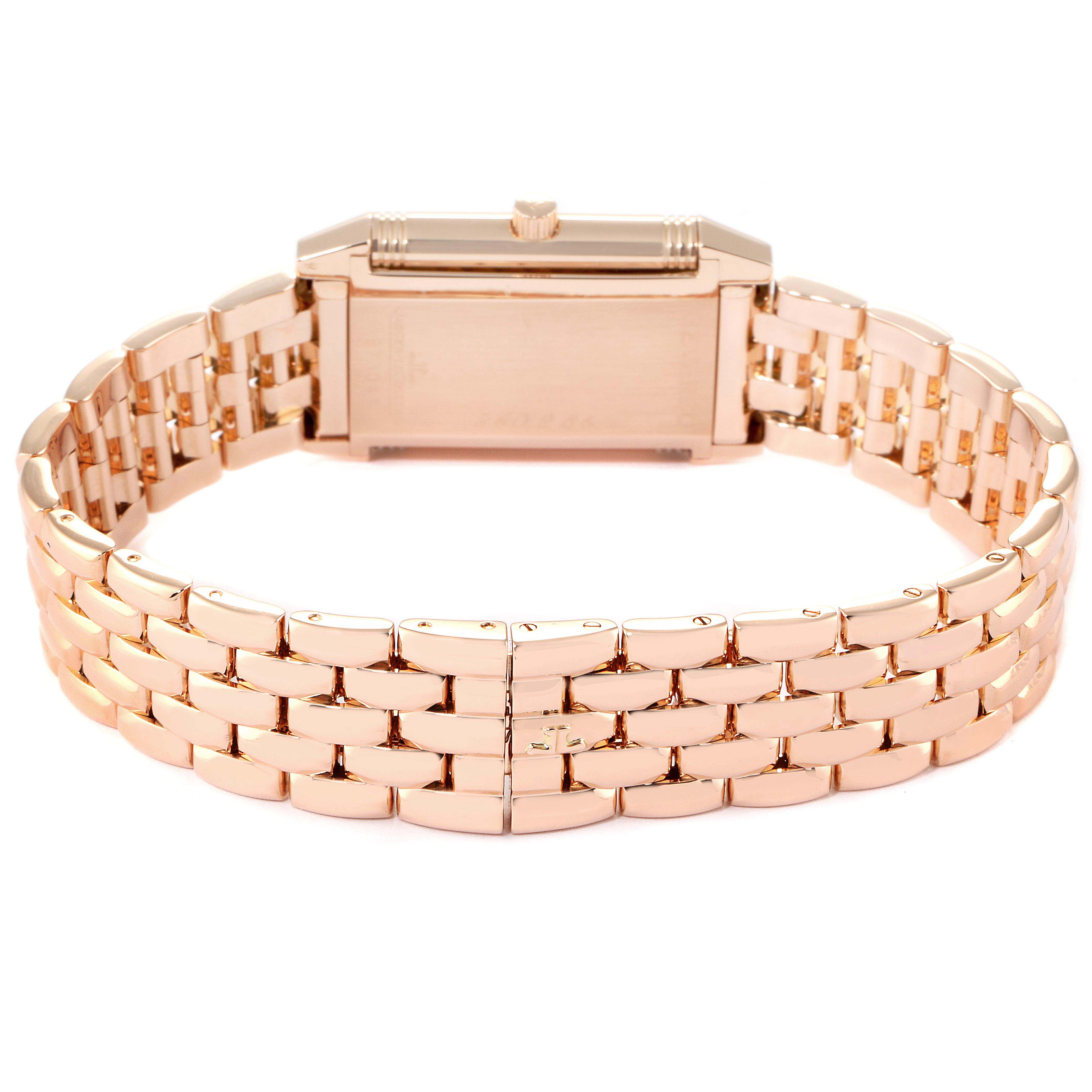 The image shows the rear view of a Jaeger-LeCoultre Reverso watch, highlighting its rectangular case and intricate link bracelet.