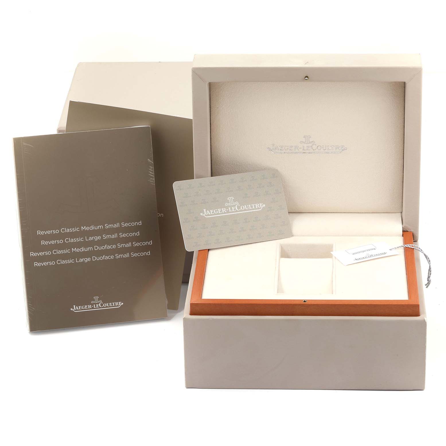 The image shows the packaging, guarantee card, and booklet for a Jaeger-LeCoultre Reverso watch, viewed from the front.
