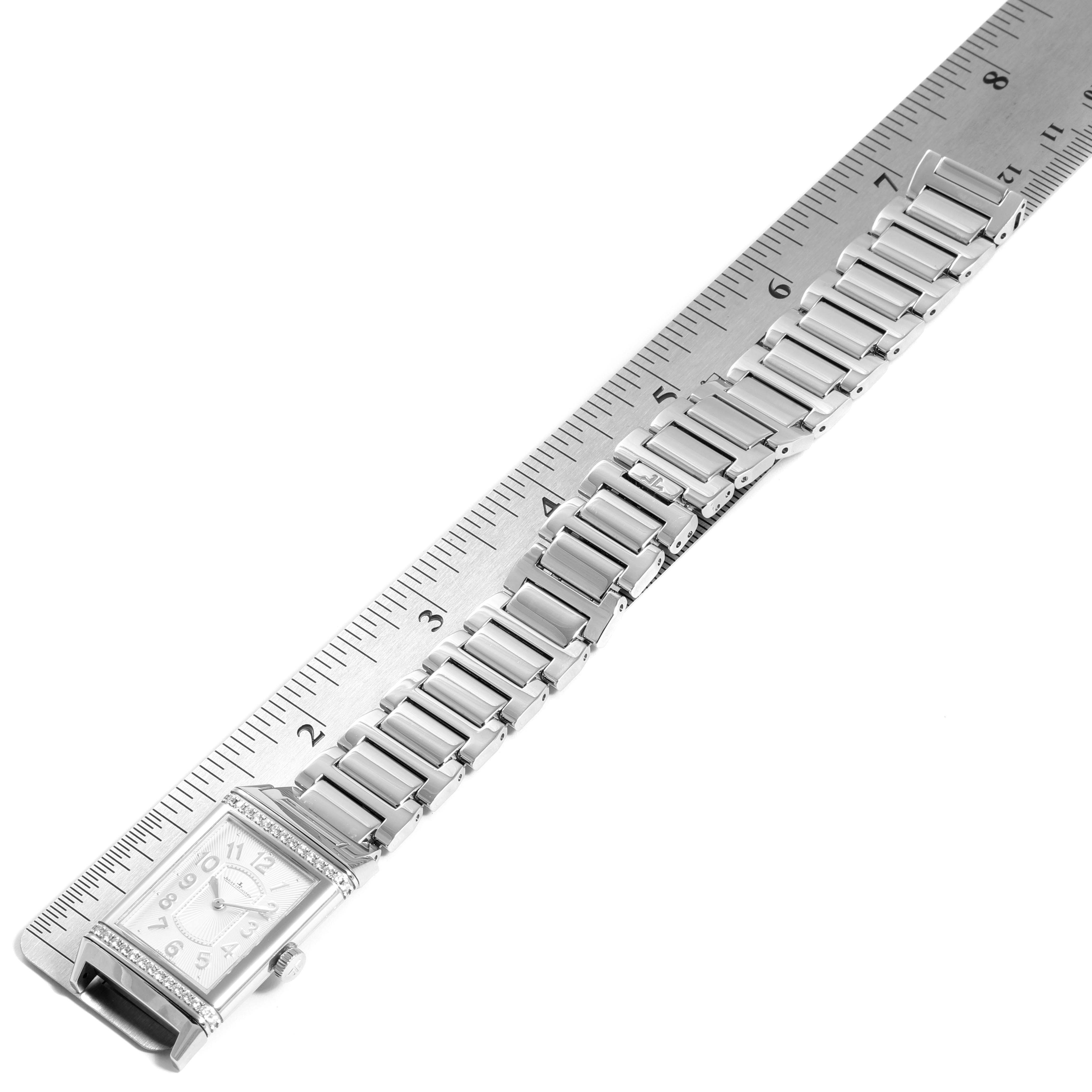 The Jaeger LeCoultre Reverso Q3208121 Women's Stainless Steel Silver Dial Q3208121 Women's Stainless Steel Silver Dial watch is shown in an angled top view with its bracelet aligned with a ruler for measurement.