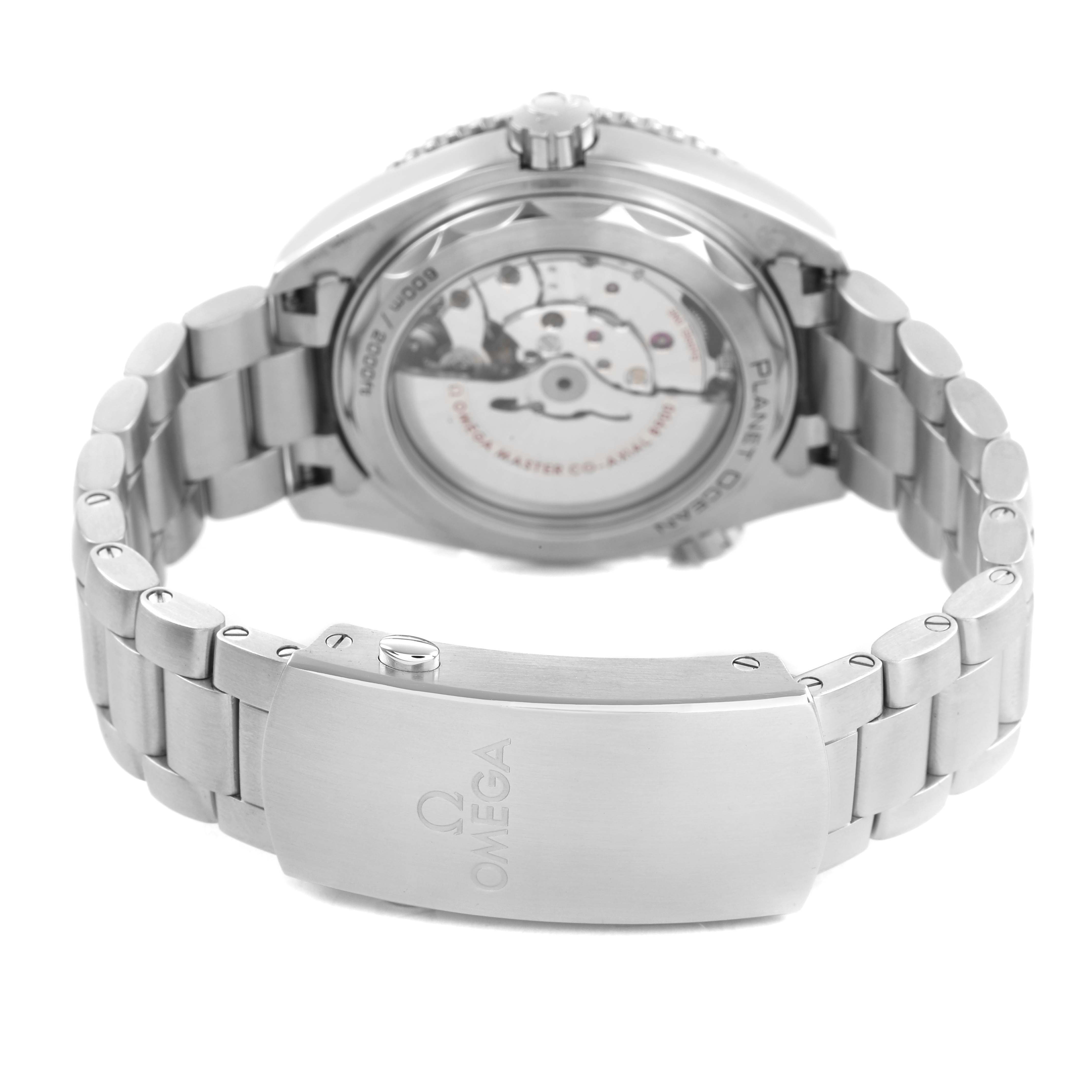 The image shows the back of an Omega Planet Ocean 215.30.44.21.03.001 Men's Stainless Steel Blue Dial watch, focusing on the open caseback and the clasp of the metal bracelet.