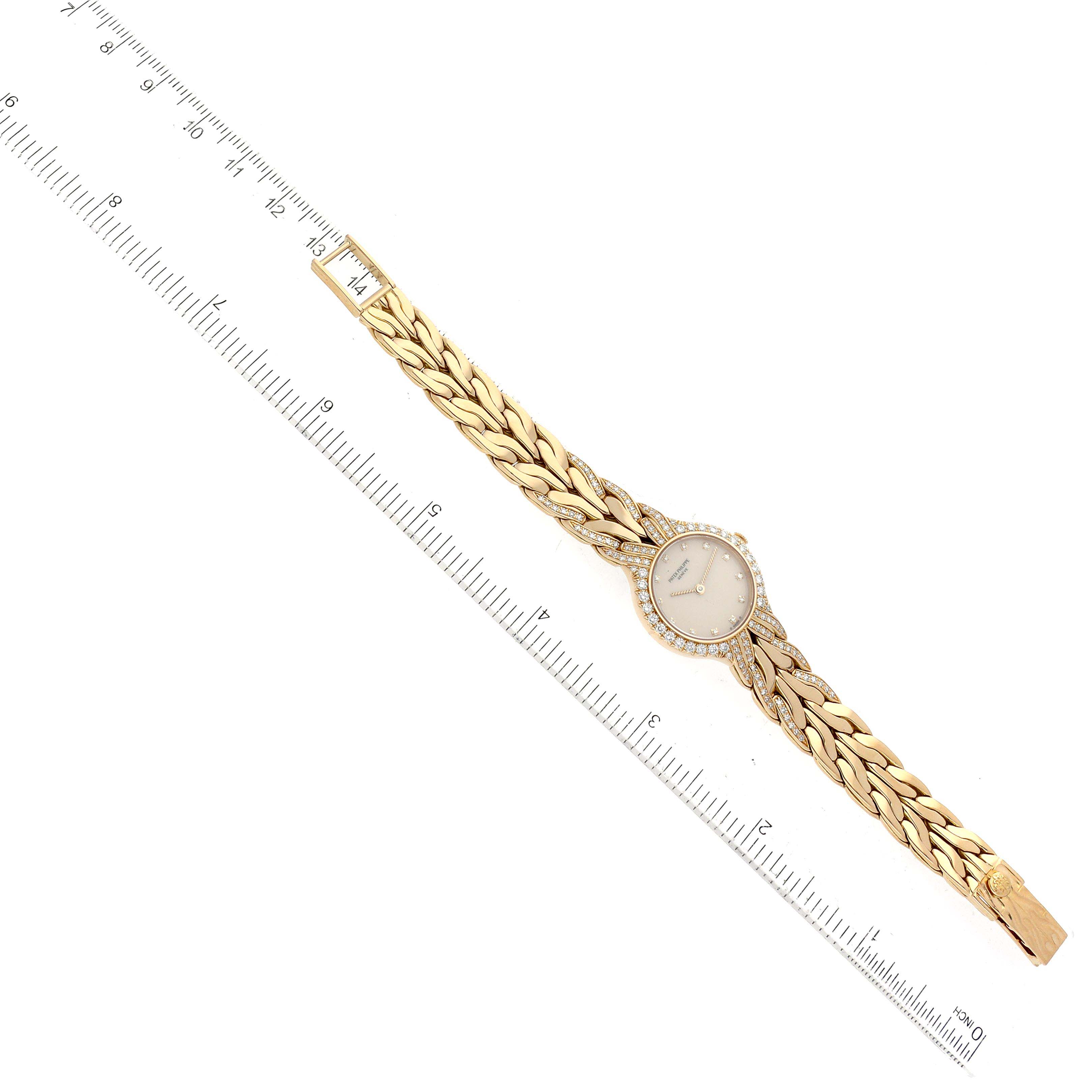 The image shows a top-down view of a Patek Philippe La Flamme  4816/3J Women's Yellow Gold Beige Dial 4816/3J Women's Yellow Gold Beige Dialwatch including its face, strap, and clasp, next to a ruler.