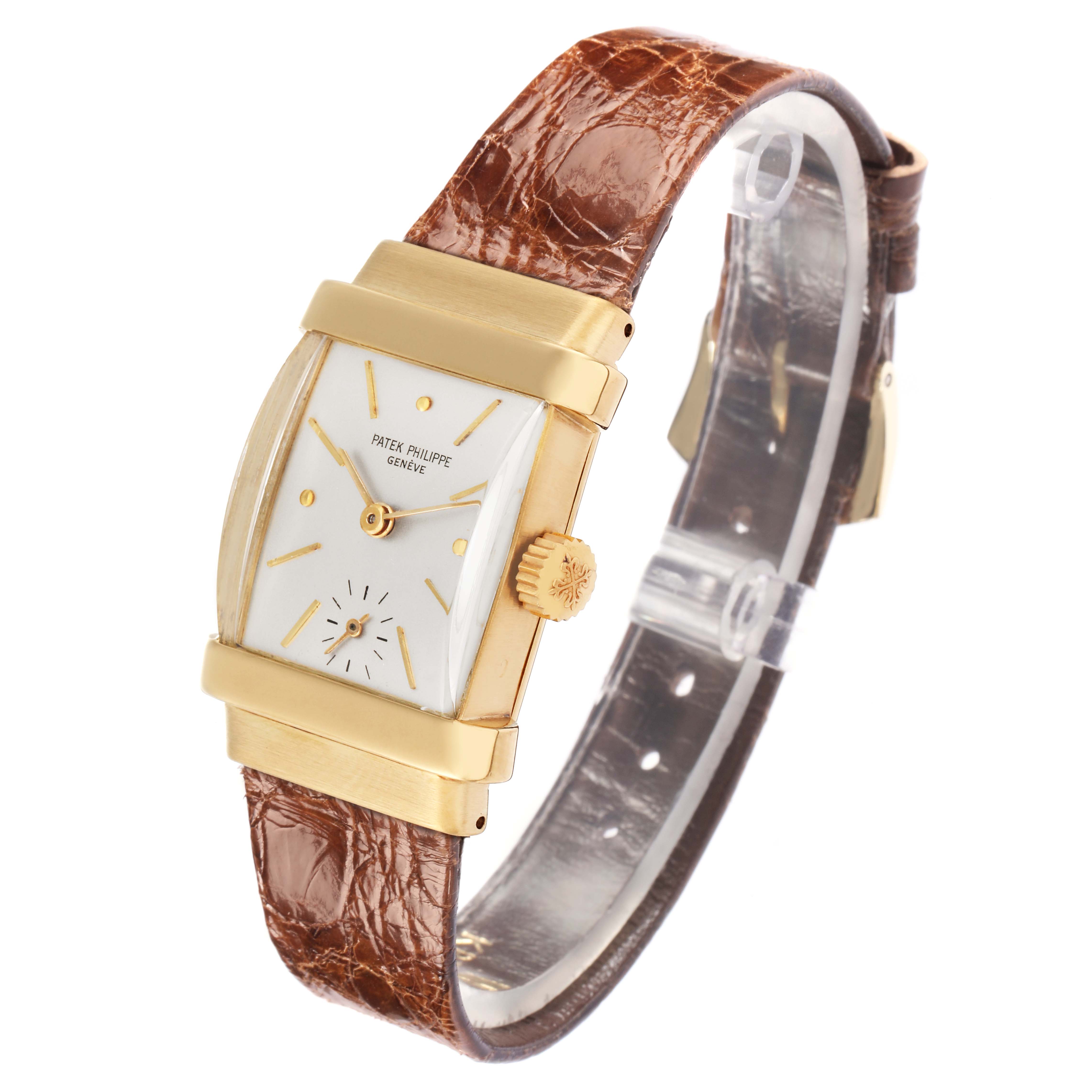 The Patek Philippe Vintage 1450 Men
s Yellow Gold Silver Dial watch is shown at an angled side view, highlighting its gold case, white dial, and brown leather strap.