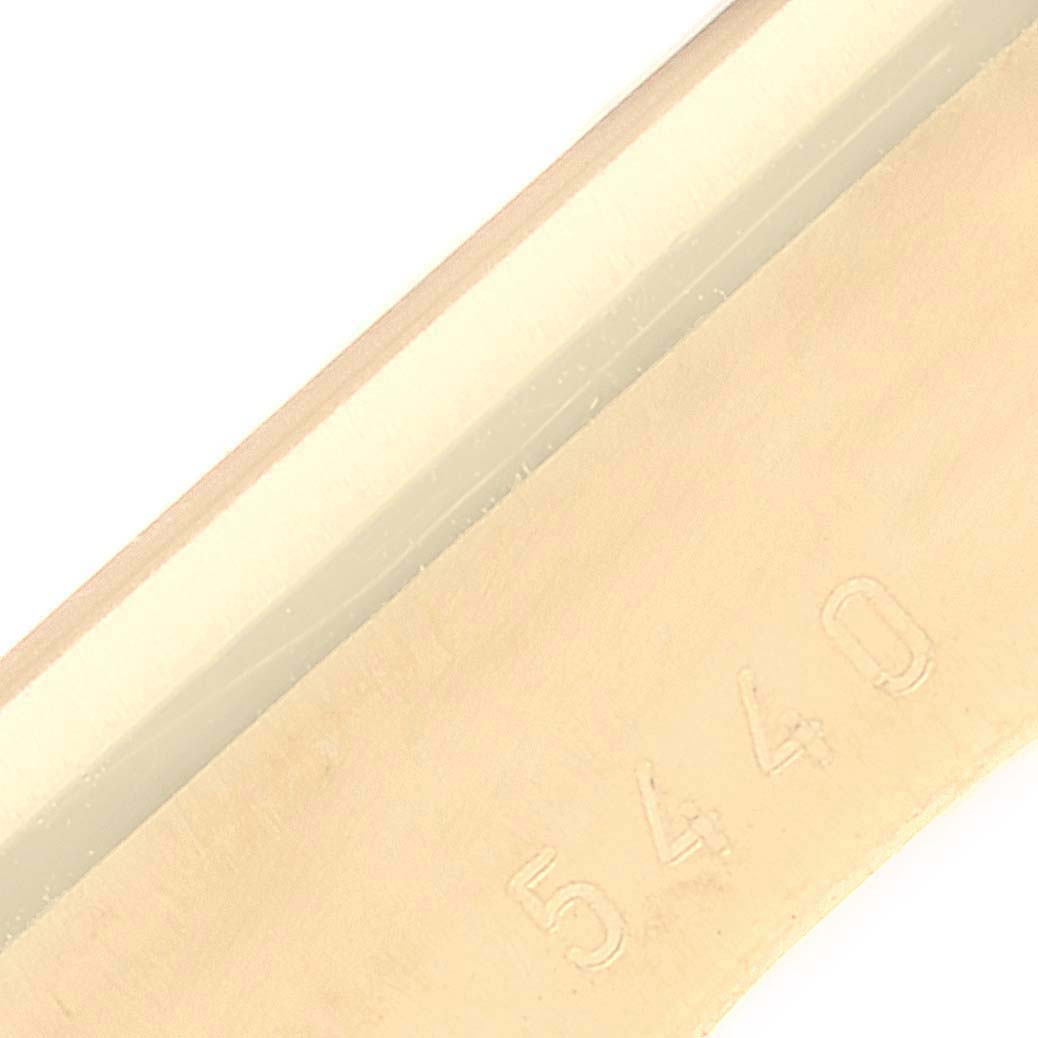 This image shows an engraved part of the Rolex Cellini 5440/8 Men's Yellow Gold Champagne Dial 5440/8 Men's Yellow Gold Champagne Dial watch from an up-close angle.