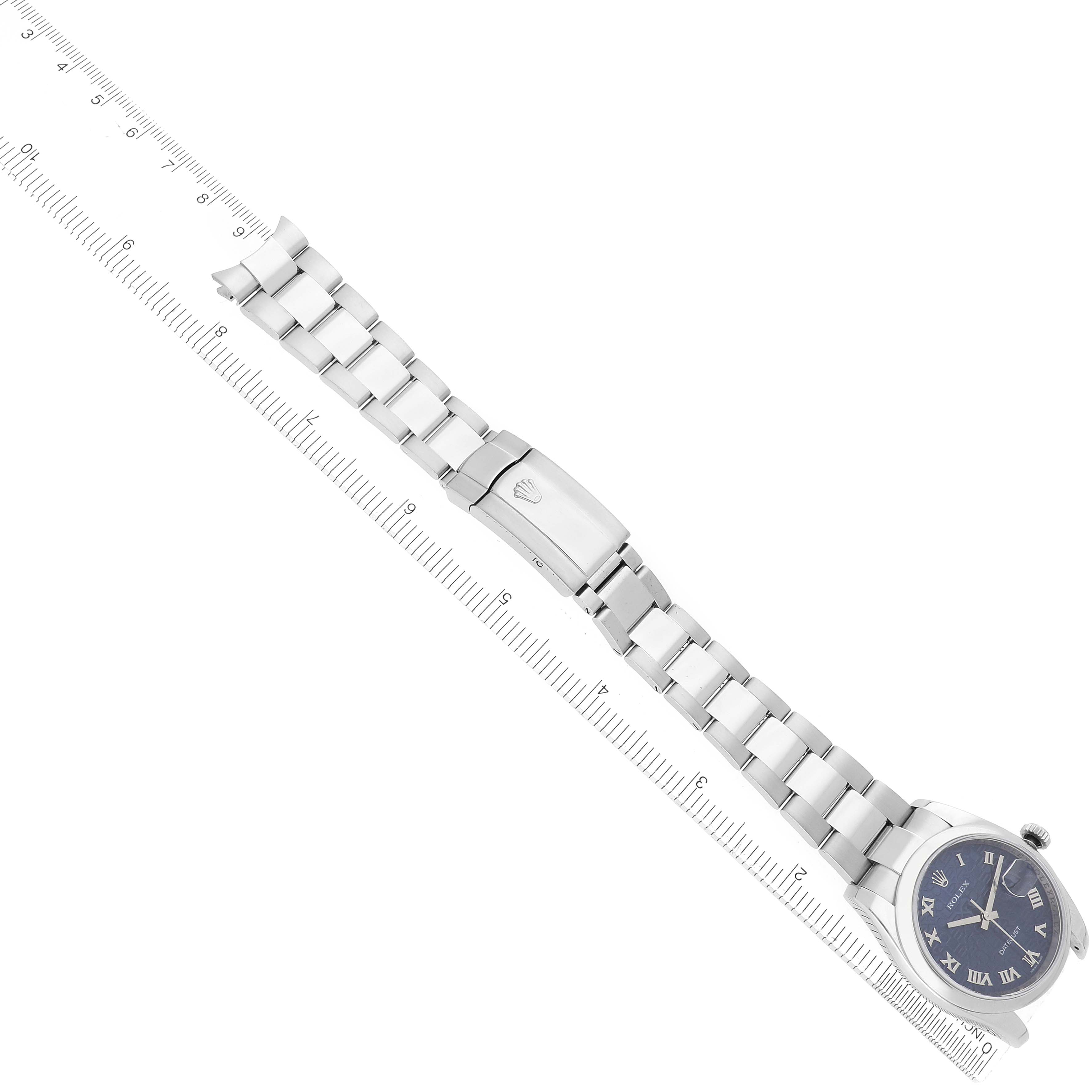 The Rolex Datejust 116200 Men
s Stainless Steel Blue Dial watch is shown from a top view, displaying the full bracelet, clasp, and face alongside a ruler for scale.