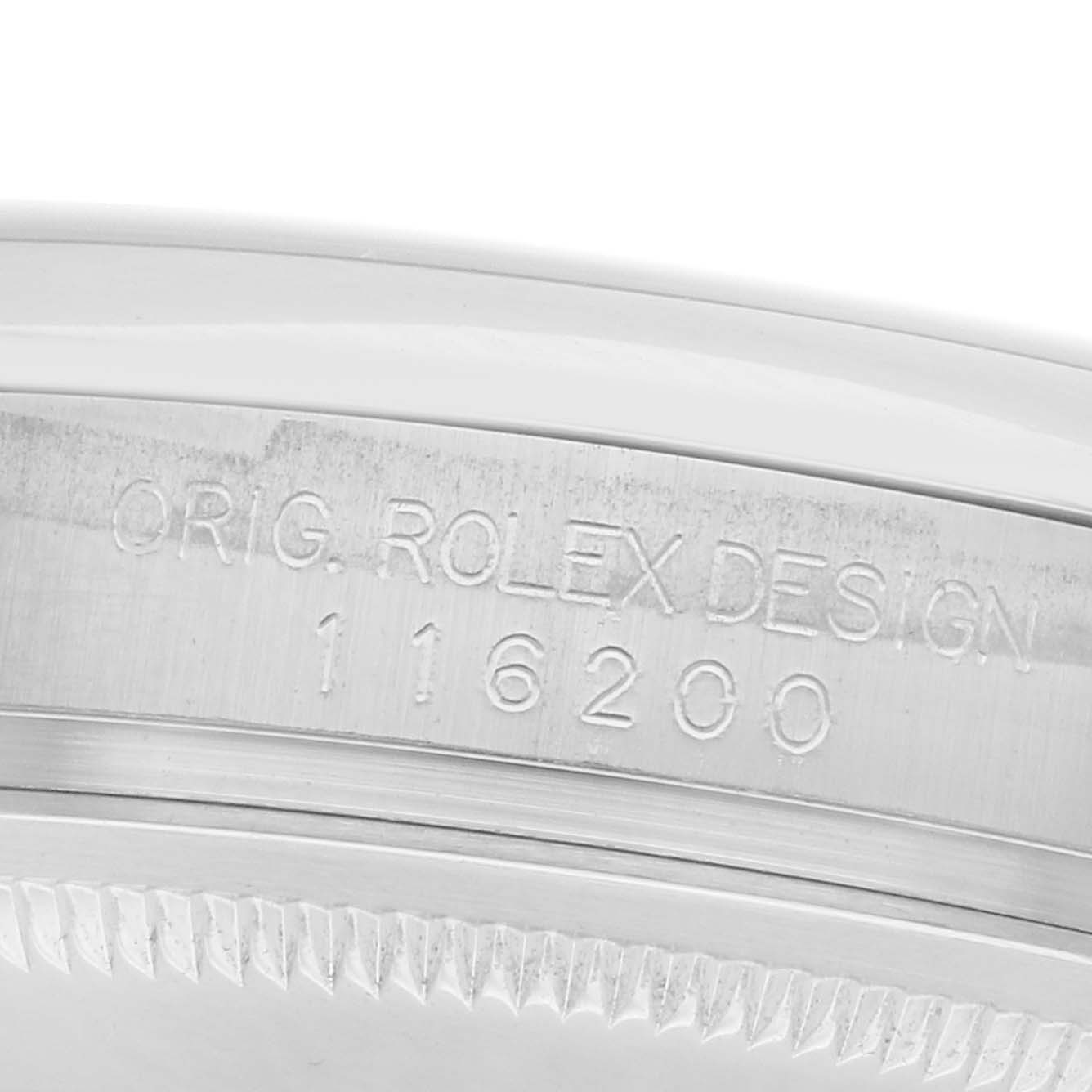 The image shows a close-up of the case side of a Rolex Datejust 116200 Men
s Stainless Steel Blue Dial, displaying the model engraving "ORIG. ROLEX DESIGN 116200".