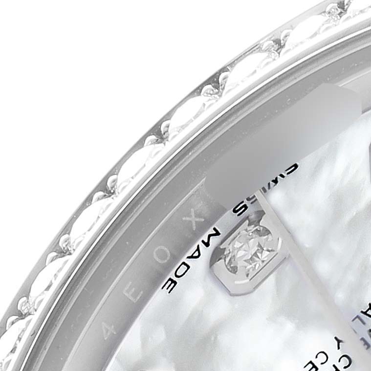 The image shows a close-up of the Rolex Mid-Size 178384 Women
s Stainless Steel Mother of Pearl Dial watch
s bezel and part of the dial with diamond markers.