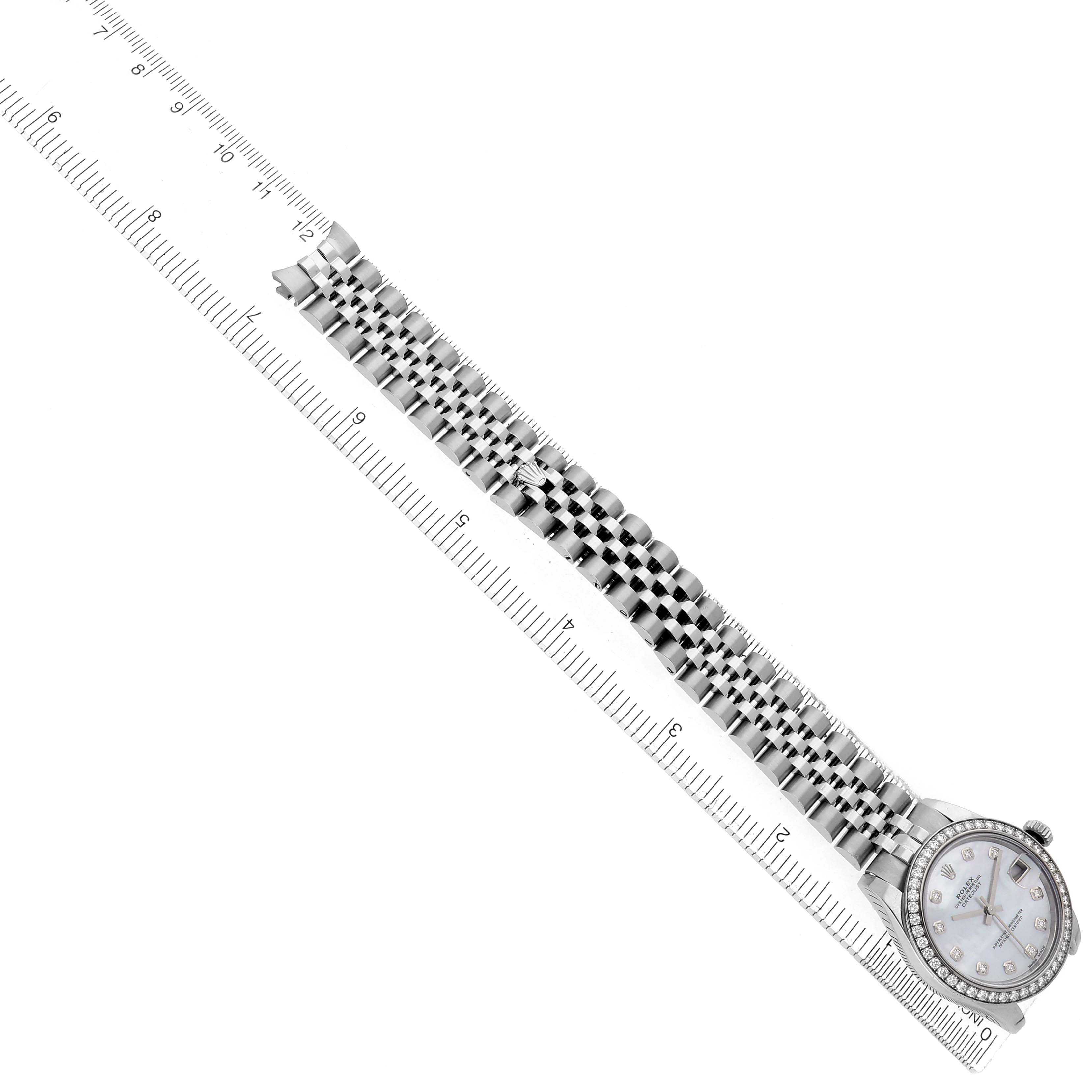 The Rolex Mid-Size 178384 Women
s Stainless Steel Mother of Pearl Dial watch is shown from a top-down angle, highlighting the entire band and face next to a measuring ruler.