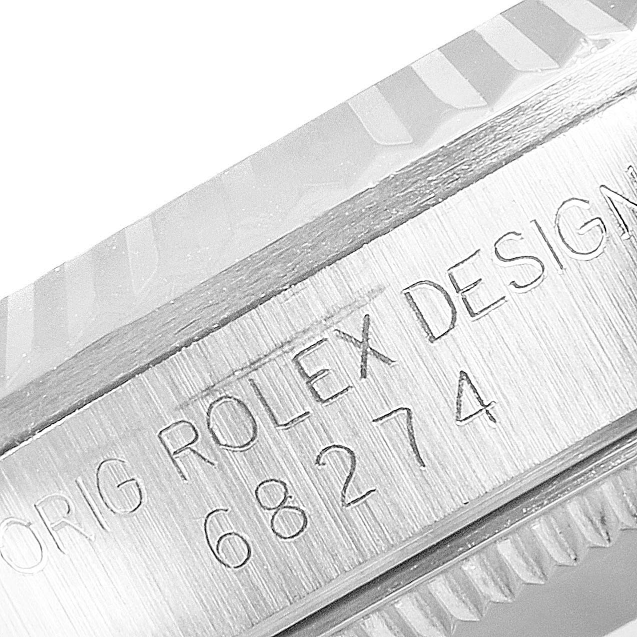 The image shows a close-up of the side of a Rolex Mid-Size 68274 Women
s Stainless Steel Silver Dial 68274 Women
s Stainless Steel Silver Dial watch case, highlighting the model number and "ROLEX DESIGN" engraving.