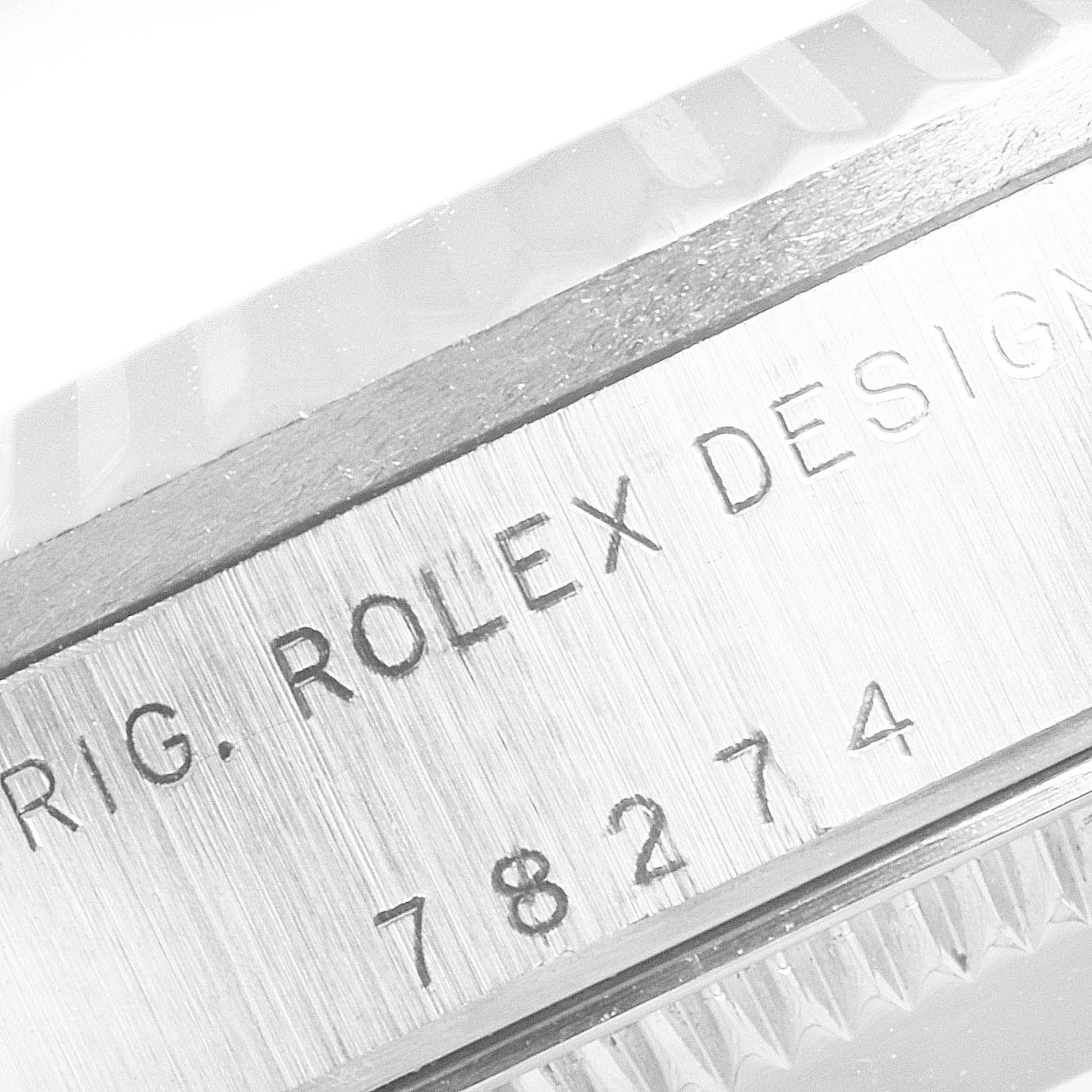 The image shows a close-up of the bezel and the serial number engraving of a Rolex Mid-Size 78274 Women
s Stainless Steel Black Dial 78274 Women
s Stainless Steel Black Dial model.