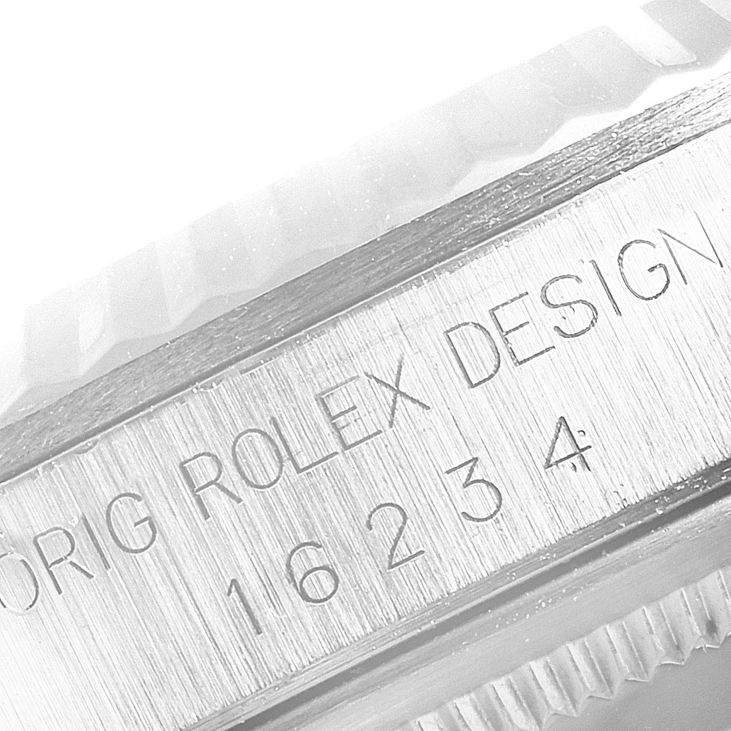 The image shows the side view of a Rolex Datejust 16234 Men's Stainless Steel Silver Dial 16234 Men's Stainless Steel Silver Dial model, focusing on the engraved model number and fluted bezel.