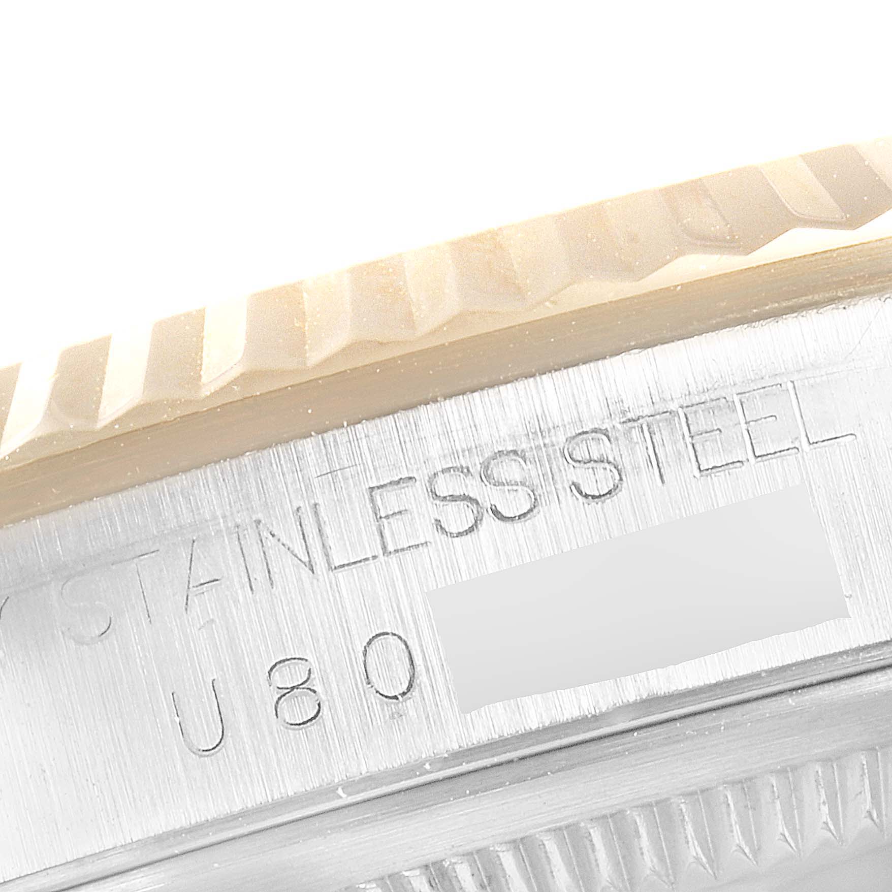 This image shows a close-up view of the side engraving and fluted bezel of a Rolex Datejust 16233 Men
s Steel and Gold (two tone) Champagne Dial 16233 Men
s Steel and Gold (two tone) Champagne Dial watch.