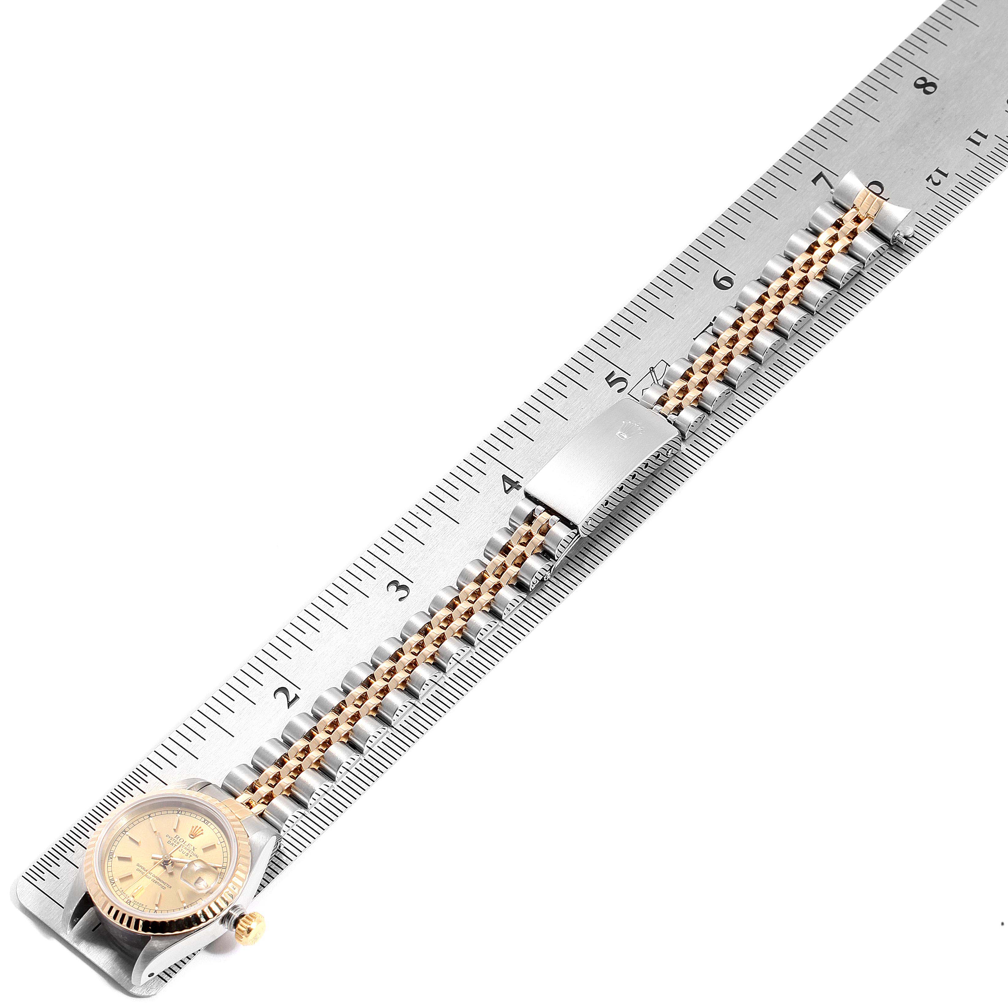 The image shows a Rolex Datejust 69173 Women's Steel and Gold (two tone) Champagne Dial 69173 Women's Steel and Gold (two tone) Champagne Dial watch laid flat on a ruler, displaying the watch's band, face, and clasp.