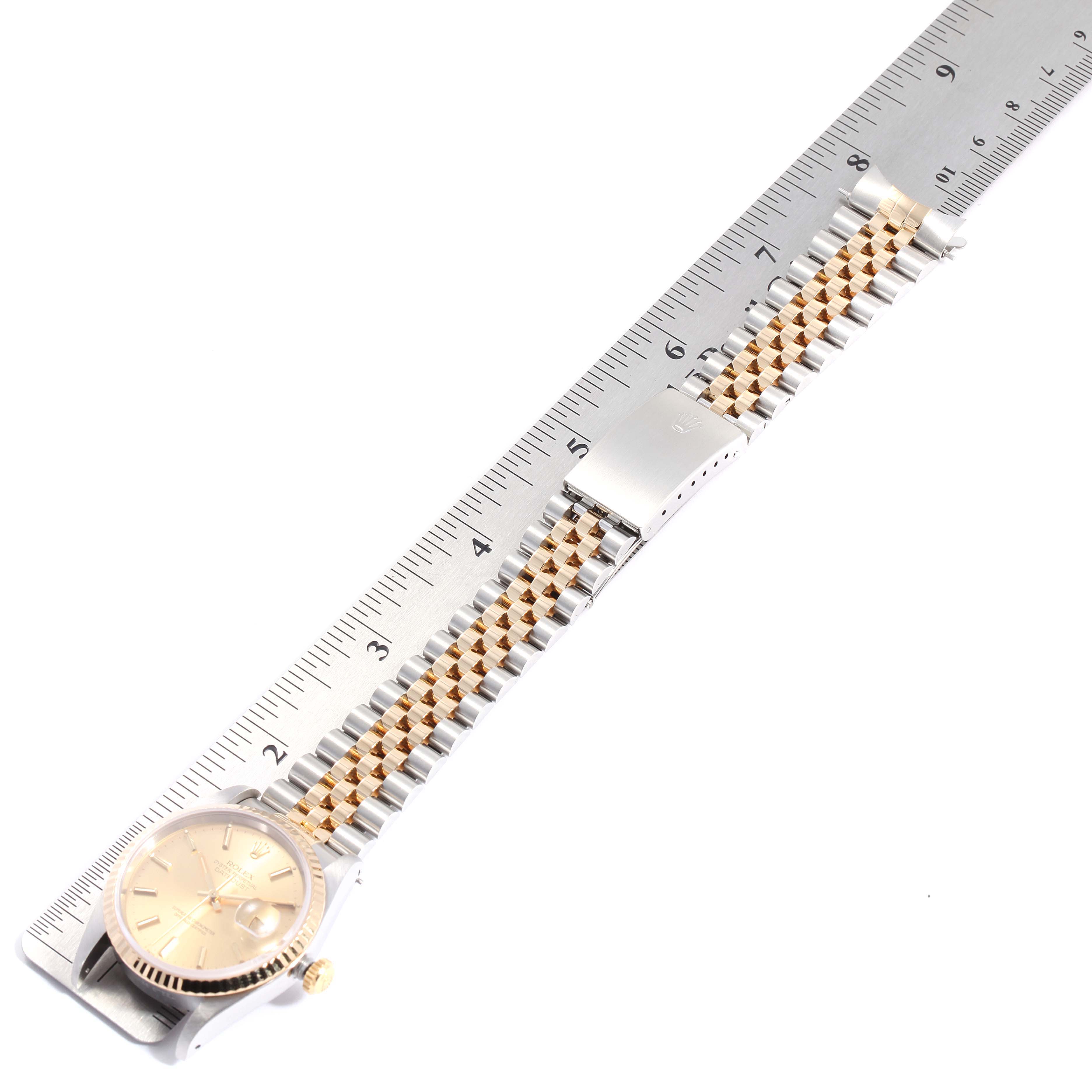 This image shows a Rolex Datejust 16233 Men's Steel and Gold (two tone) Champagne Dial 16233 Men's Steel and Gold (two tone) Champagne Dial watch flat, measuring its bracelet length with a ruler.