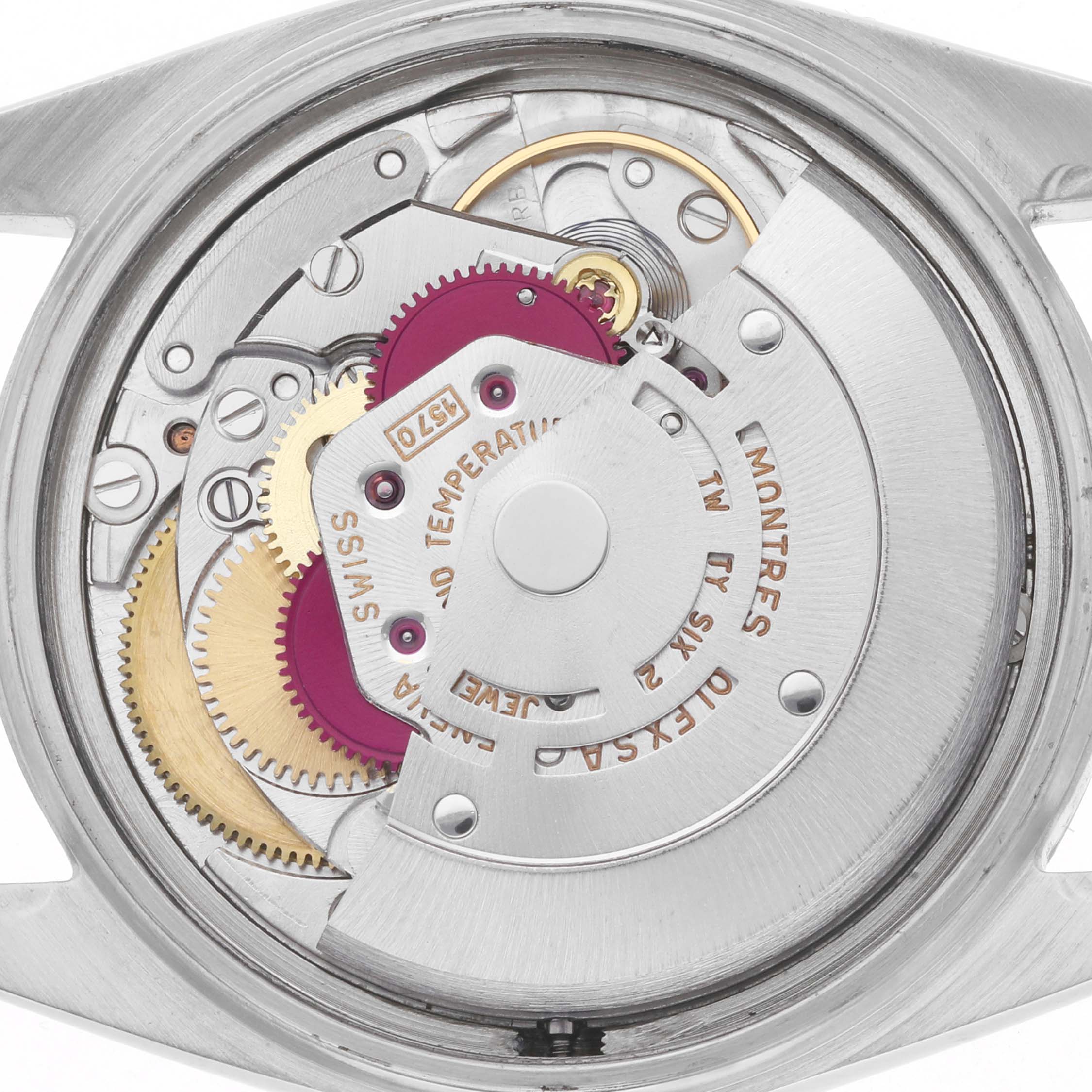 The image shows the inner mechanical movement of a Rolex Vintage Collection 1601 Men
s Stainless Steel Silver Dial watch from a rear angle, highlighting gears and components.