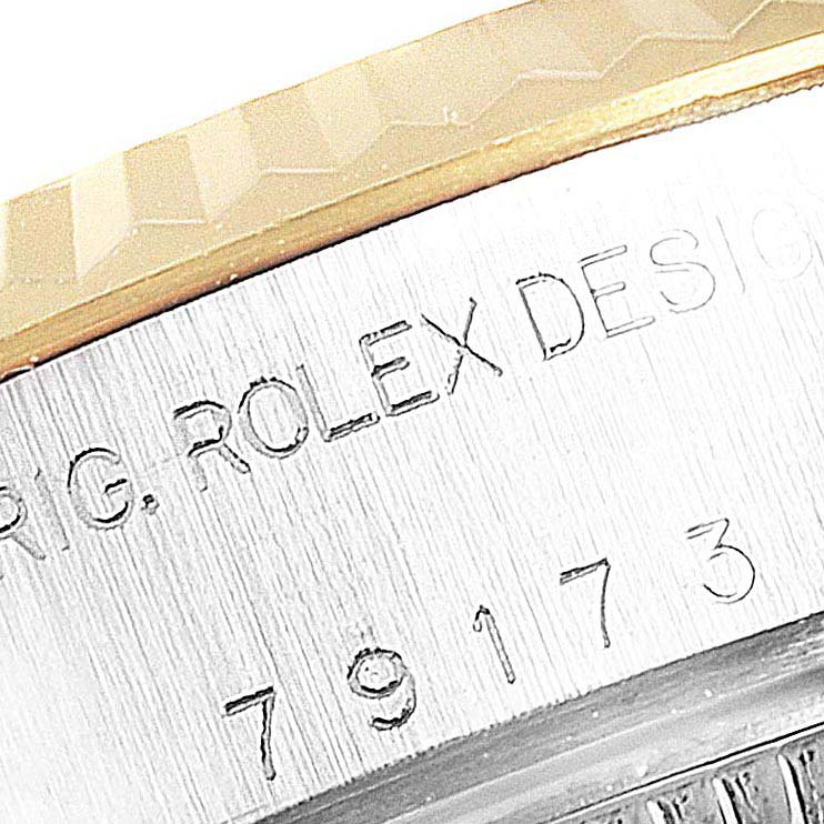 This close-up angle of the Rolex Datejust 79173 Women's Steel and Gold (two tone) Silver Dial 79173 Women's Steel and Gold (two tone) Silver Dial shows the engraved model number and part of the fluted bezel.