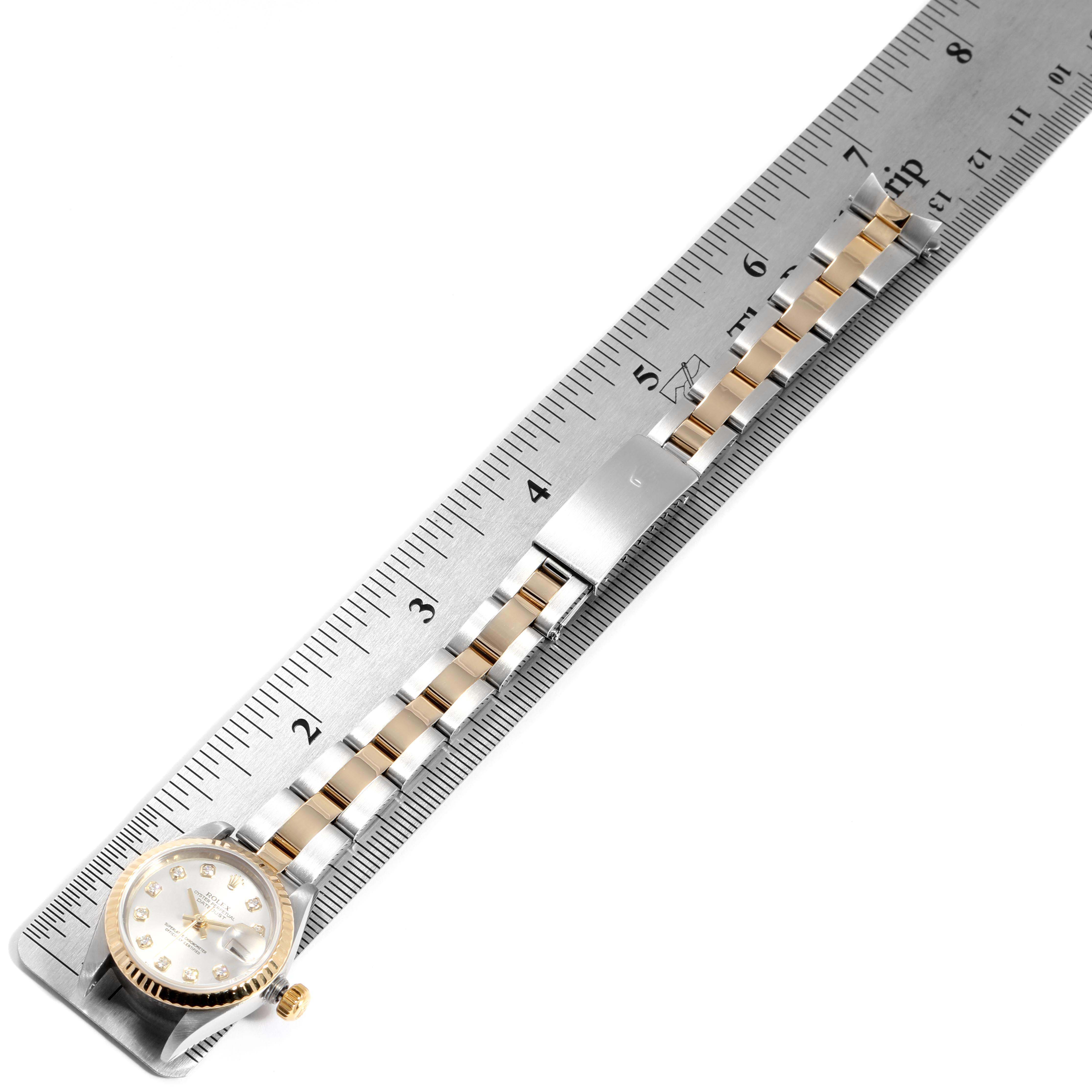 This top-down view shows the face, bracelet, and clasp of the Rolex Datejust 79173 Women's Steel and Gold (two tone) Silver Dial 79173 Women's Steel and Gold (two tone) Silver Dial watch next to a ruler for scale.