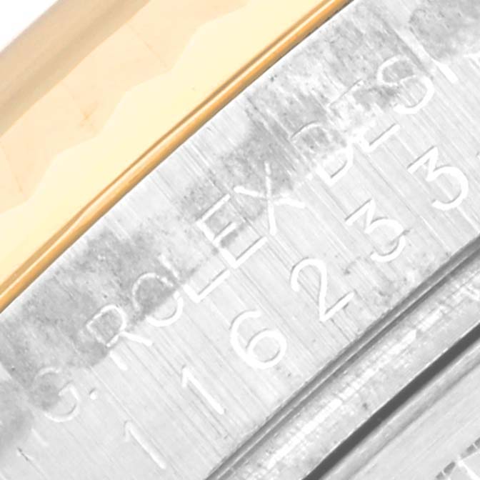 The image shows a close-up of the engraved side of a Rolex Datejust 116233 Men's Steel and Gold (two tone) White Dial 116233 Men's Steel and Gold (two tone) White Dial watch case.