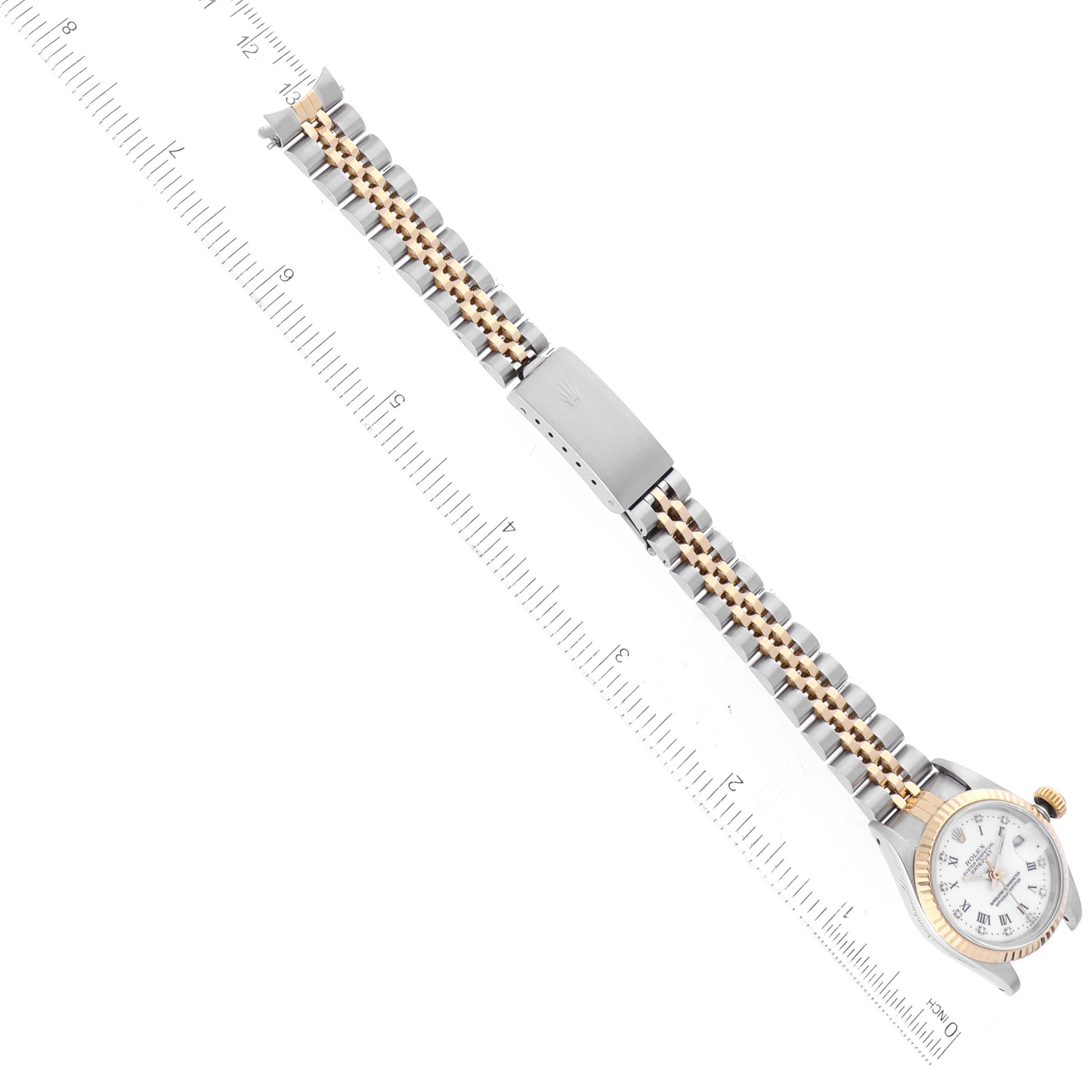 This image shows the Rolex Datejust 69173 Women's Steel and Gold (two tone) White Dial 69173 Women's Steel and Gold (two tone) White Dial watch laid flat, displaying the face, bracelet, and deployment clasp alongside a ruler for scale.