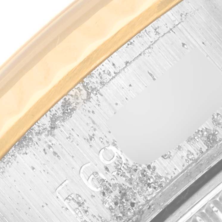 This close-up image shows the case side of a Rolex Datejust 69173 Women's Steel and Gold (two tone) White Dial 69173 Women's Steel and Gold (two tone) White Dial model, highlighting the bezel and a portion of the engravings.