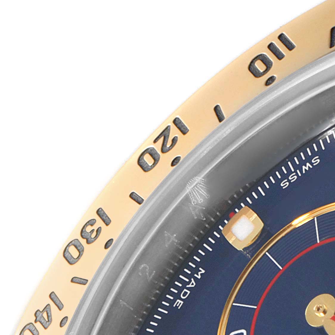 The image shows a close-up angle of the bezel and part of the dial of a Rolex Daytona 116523 Men's Steel and Gold (two tone) Blue Dial watch.