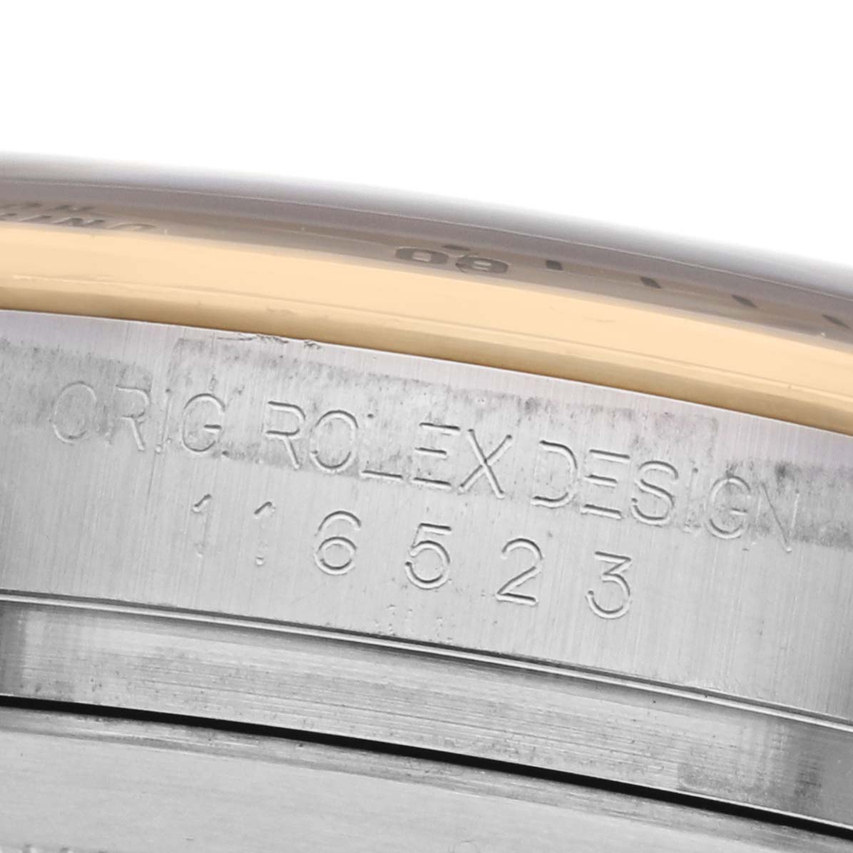 The image shows the side of a Rolex Daytona 116523 Men's Steel and Gold (two tone) Blue Dial watch case with engraved model details.