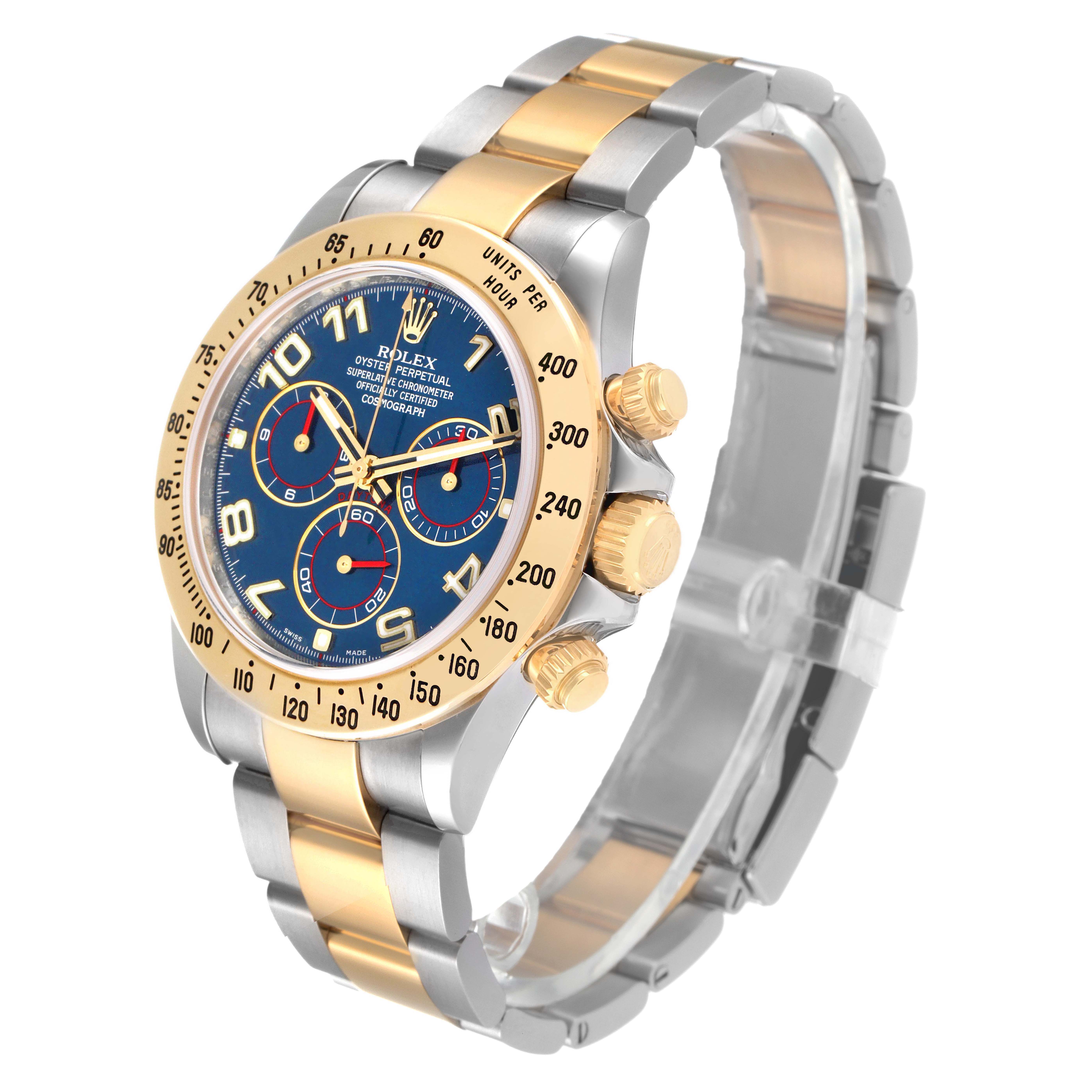 The Rolex Daytona 116523 Men's Steel and Gold (two tone) Blue Dial watch is shown at a slight side angle, highlighting its face, bezel, and part of the bracelet.