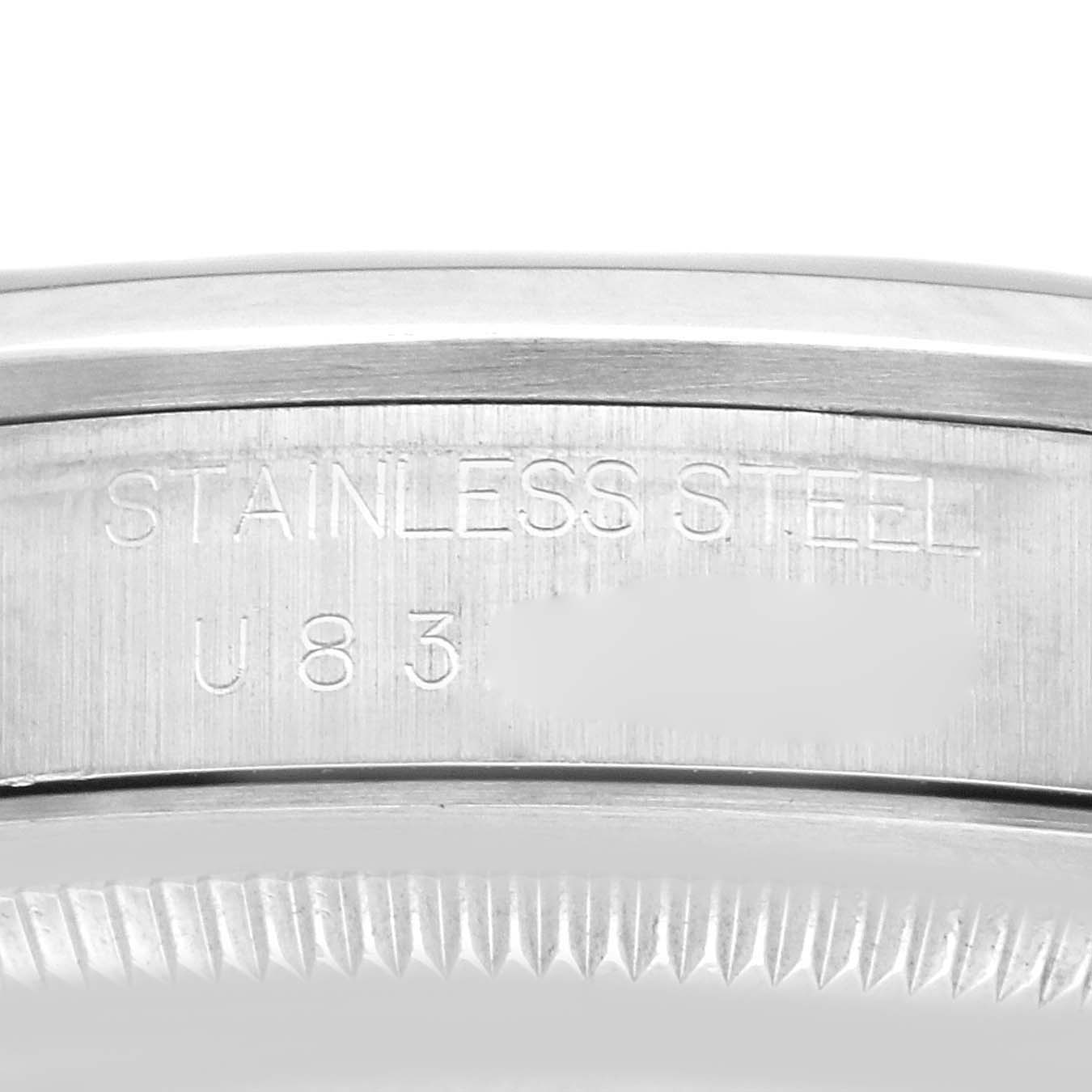 The image shows a close-up of the outer edge of the Rolex Explorer 14270 Men
s Stainless Steel Black Dial watch, highlighting "STAINLESS STEEL" engraving and the serial number.