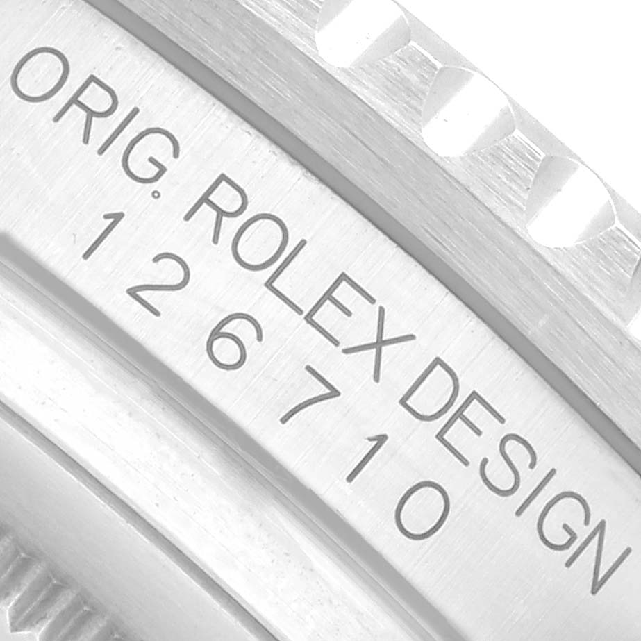 The image shows a close-up of the side of a Rolex GMT-Master 126710 Men
s Stainless Steel Black Dial, featuring its engraved model number and design text.
