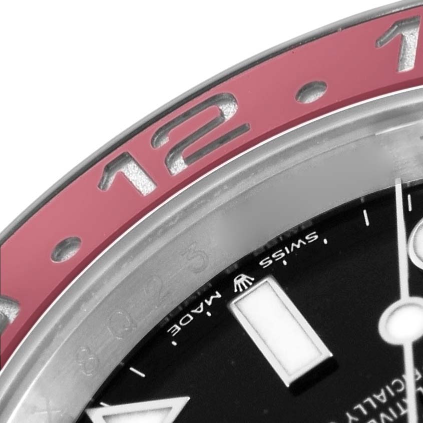 The image shows a close-up of the bezel and dial of a Rolex GMT-Master 126710 Men
s Stainless Steel Black Dial, focusing on the 12-hour marker.