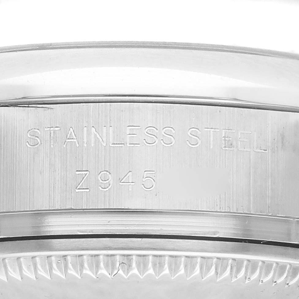 This image shows a close-up view of the side of a stainless steel Rolex Oyster Perpetual 176200 Women's Stainless Steel Black Dial 176200 Women's Stainless Steel Black Dial watch case, displaying engraved text.