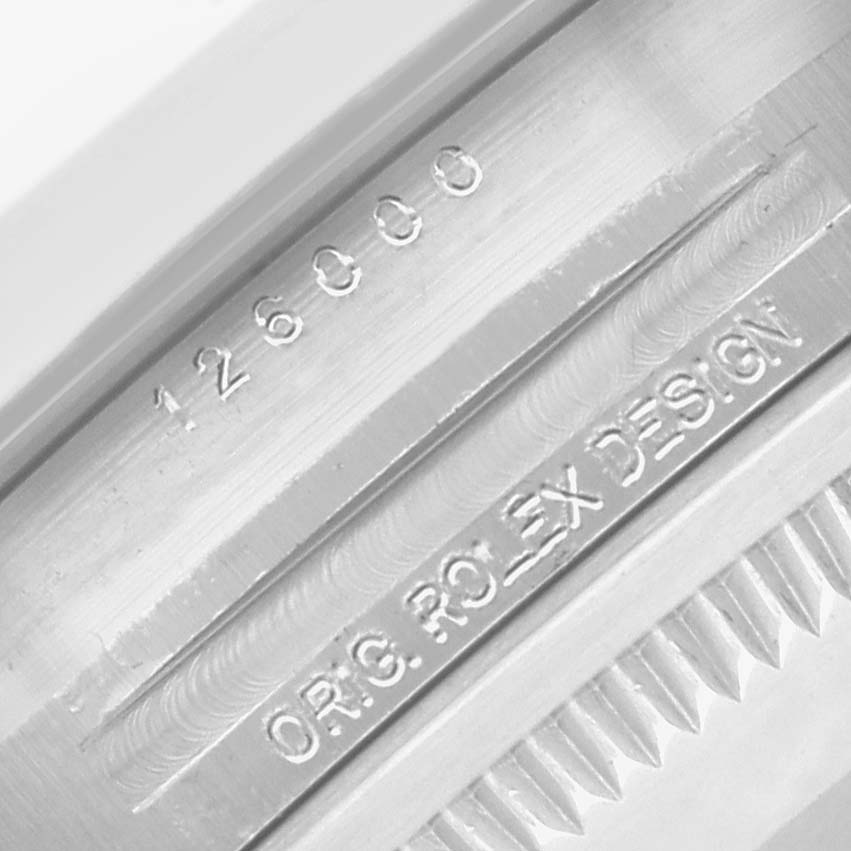 This image shows a close-up of the serial number and "ORIG ROLEX DESIGN" engraving on the side of a Rolex Oyster Perpetual 126000 Men
s Stainless Steel Blue Dial watch case.