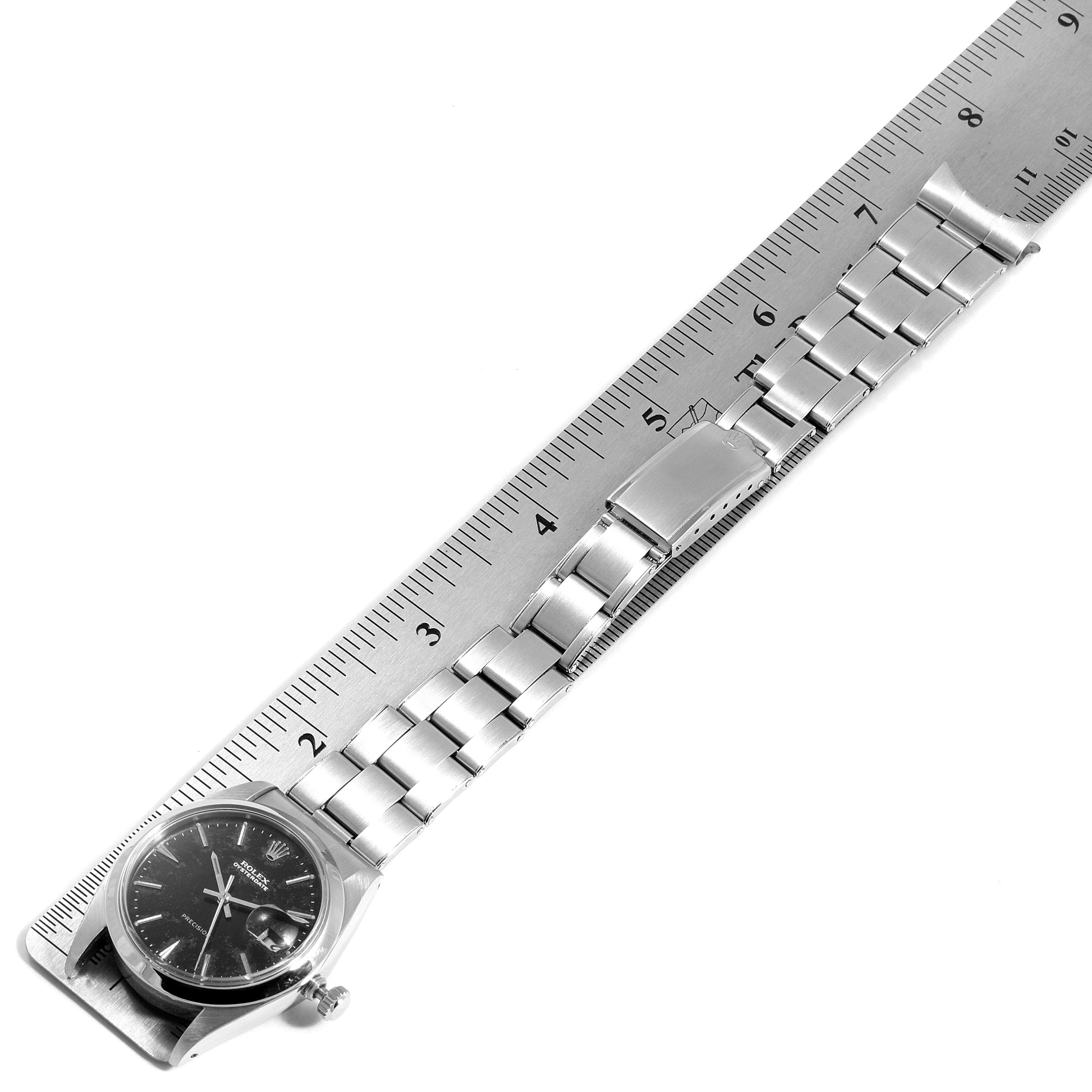 The image shows the Rolex Vintage Collection 6694 Men's Stainless Steel Black Dial 6694 Men's Stainless Steel Black Dial model watch laid flat next to a ruler, displaying its full bracelet and clasp.