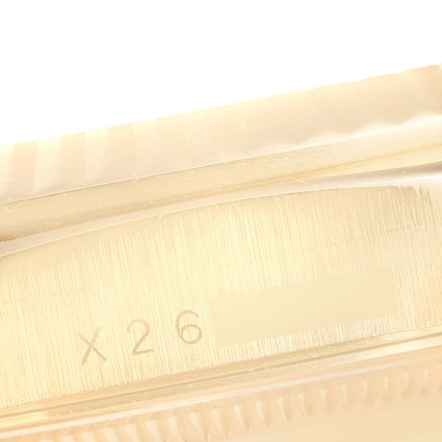 The image shows a close-up angle of the side of a Rolex President 18038 Men's Yellow Gold Champagne Dial 18038 Men's Yellow Gold Champagne Dial model watch, focusing on its engravings.