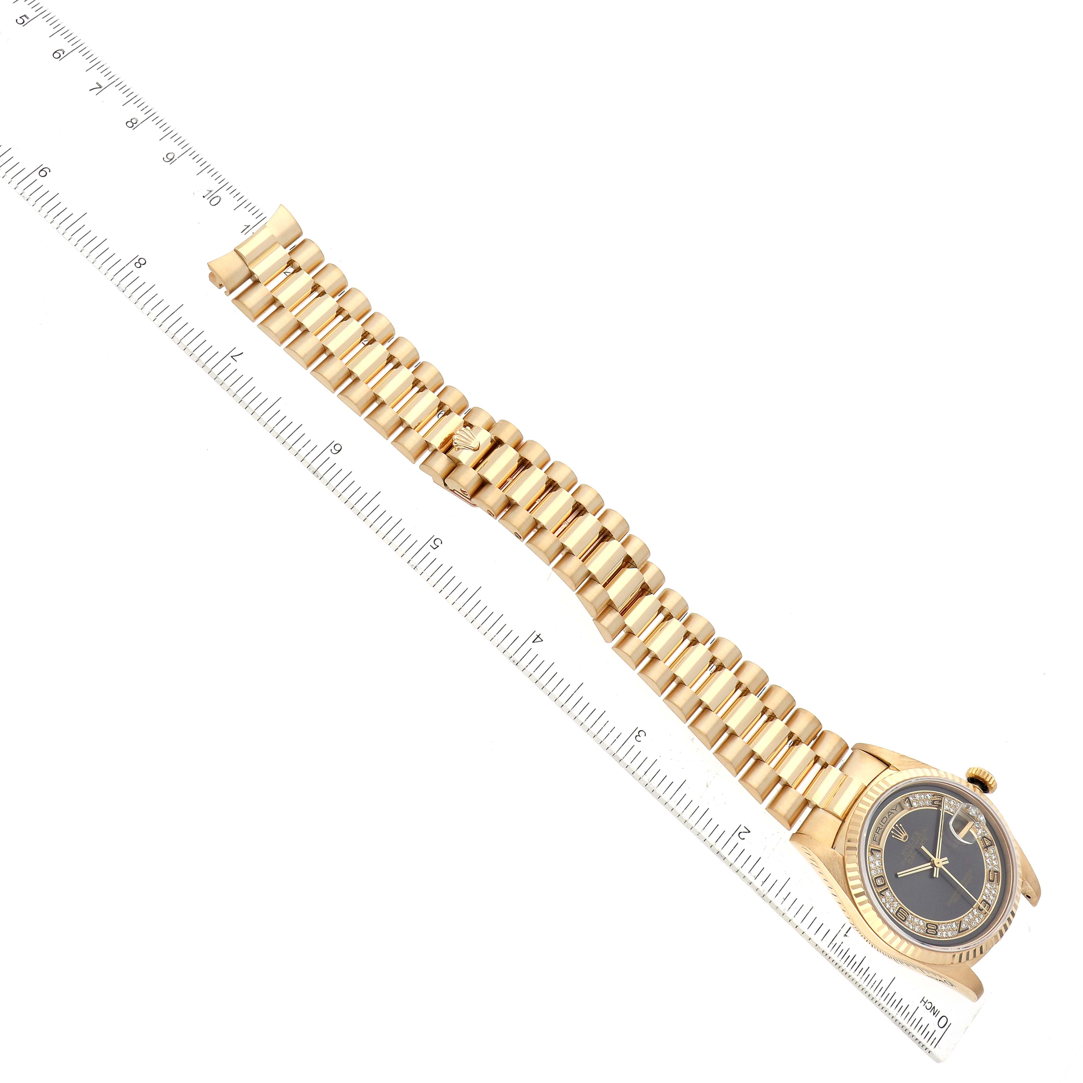 The Rolex President 18238 Men's Yellow Gold Grey Dial 18238 Men's Yellow Gold Grey Dial model watch is shown from an overhead angle, displaying the gold band and face next to a ruler for scale.