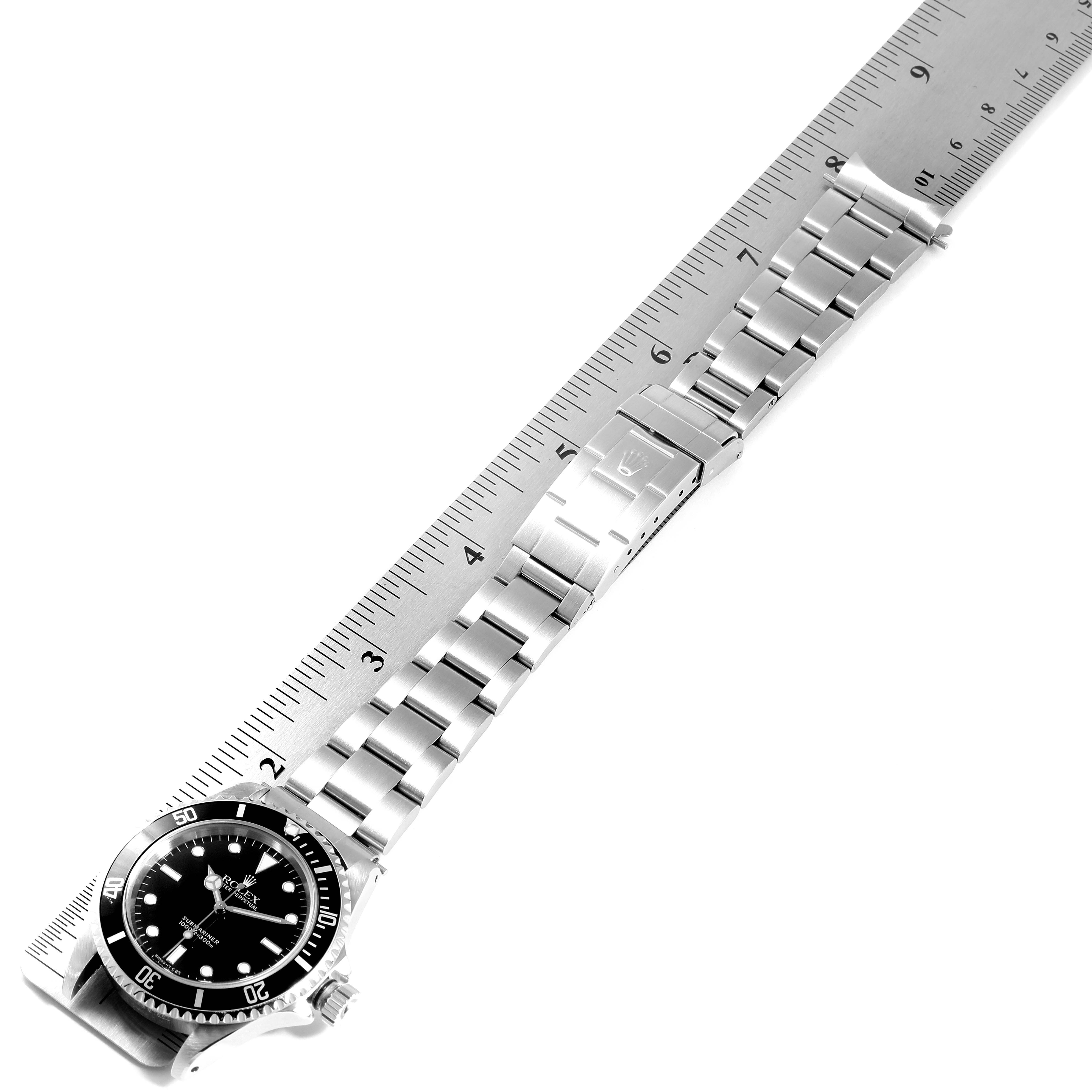 The image shows a top-down view of the entire Rolex Submariner 14060 Men
s Stainless Steel Black Dial 14060 Men
s Stainless Steel Black Dial watch alongside a ruler for scale.