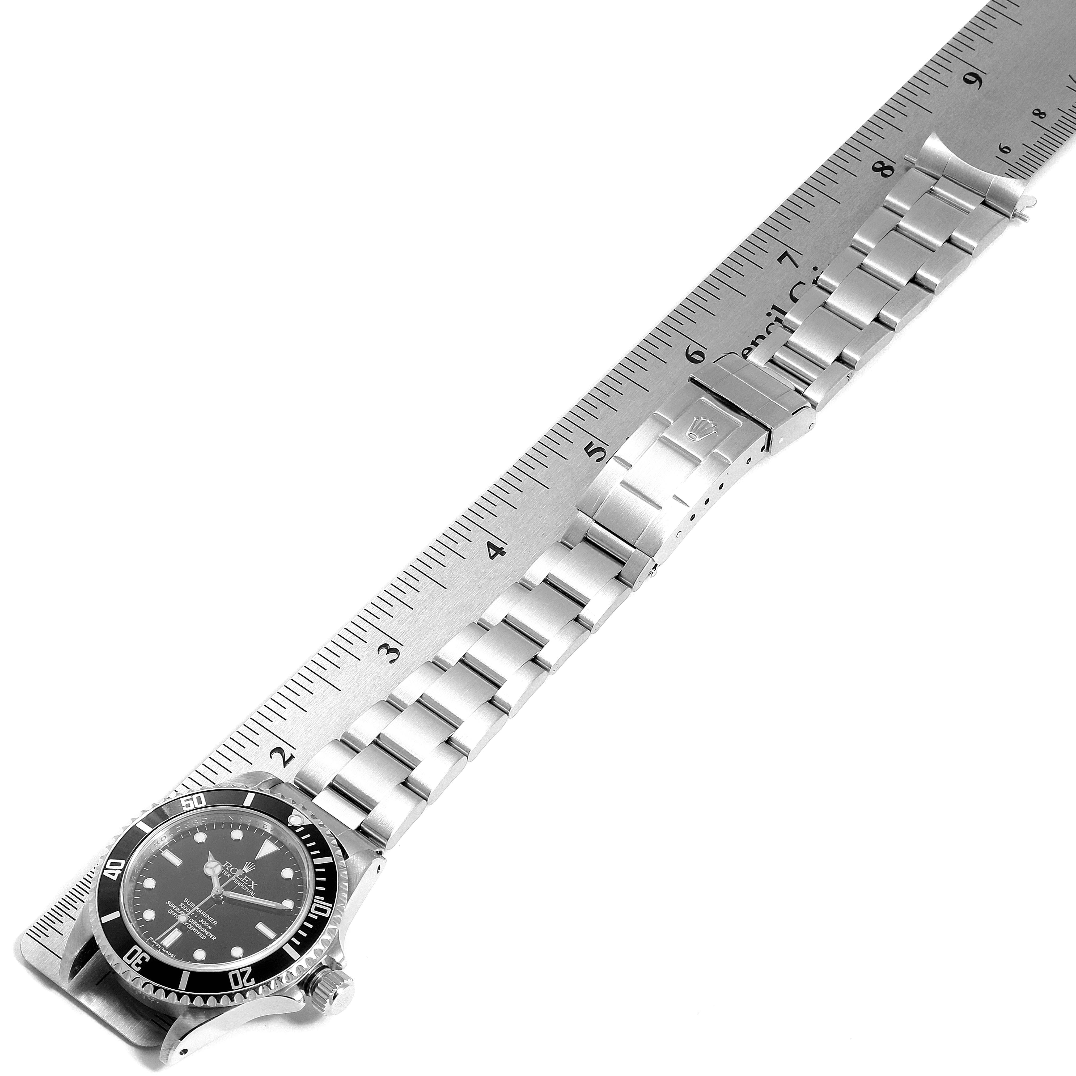 The image shows the Rolex Submariner 14060 Men's Stainless Steel Black Dial 14060 Men's Stainless Steel Black Dial watch laid flat next to a ruler, displaying its face, bezel, and metal bracelet.