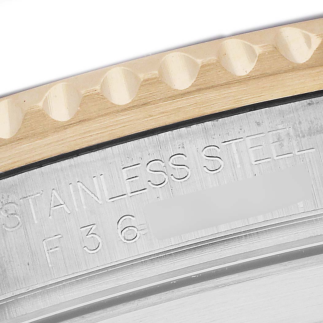 The image shows a close-up of the bezel and case back of a Rolex Submariner 16613 Men
s Steel and Gold (two tone) Blue Dial, highlighting the stainless steel engraving.