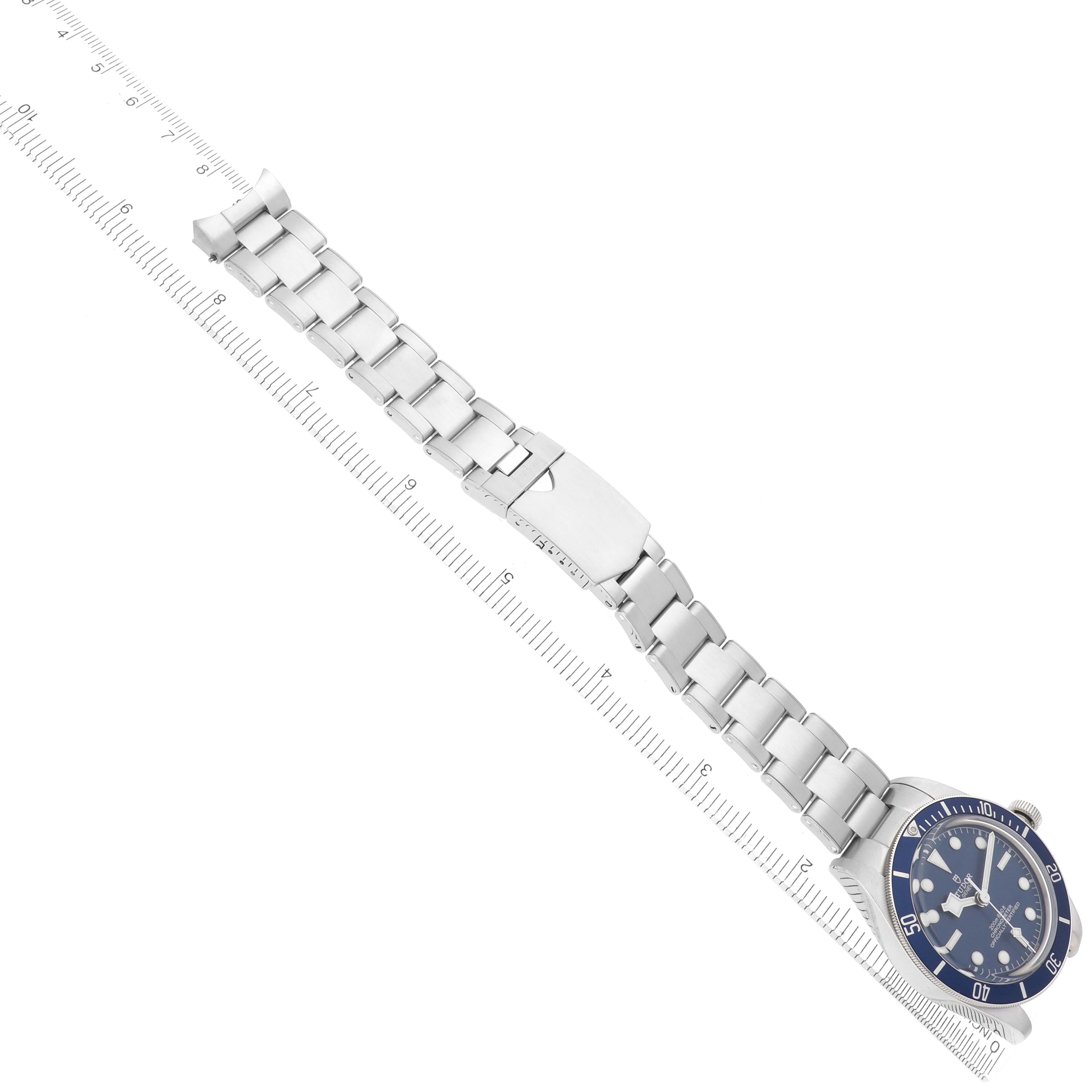 The Tudor Heritage Black Bay 79030B Men
s Stainless Steel Blue Dial watch is shown from an overhead angle, highlighting its bracelet and clasp alongside a ruler for scale.