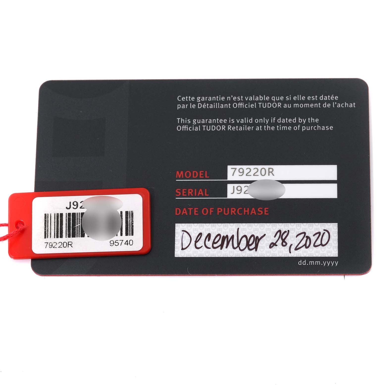 This image shows the warranty card and tag for a Tudor Heritage Black Bay 79220R Men
s Stainless Steel Black Dial 79220R Men
s Stainless Steel Black Dial model 79220R with a visible date of purchase.