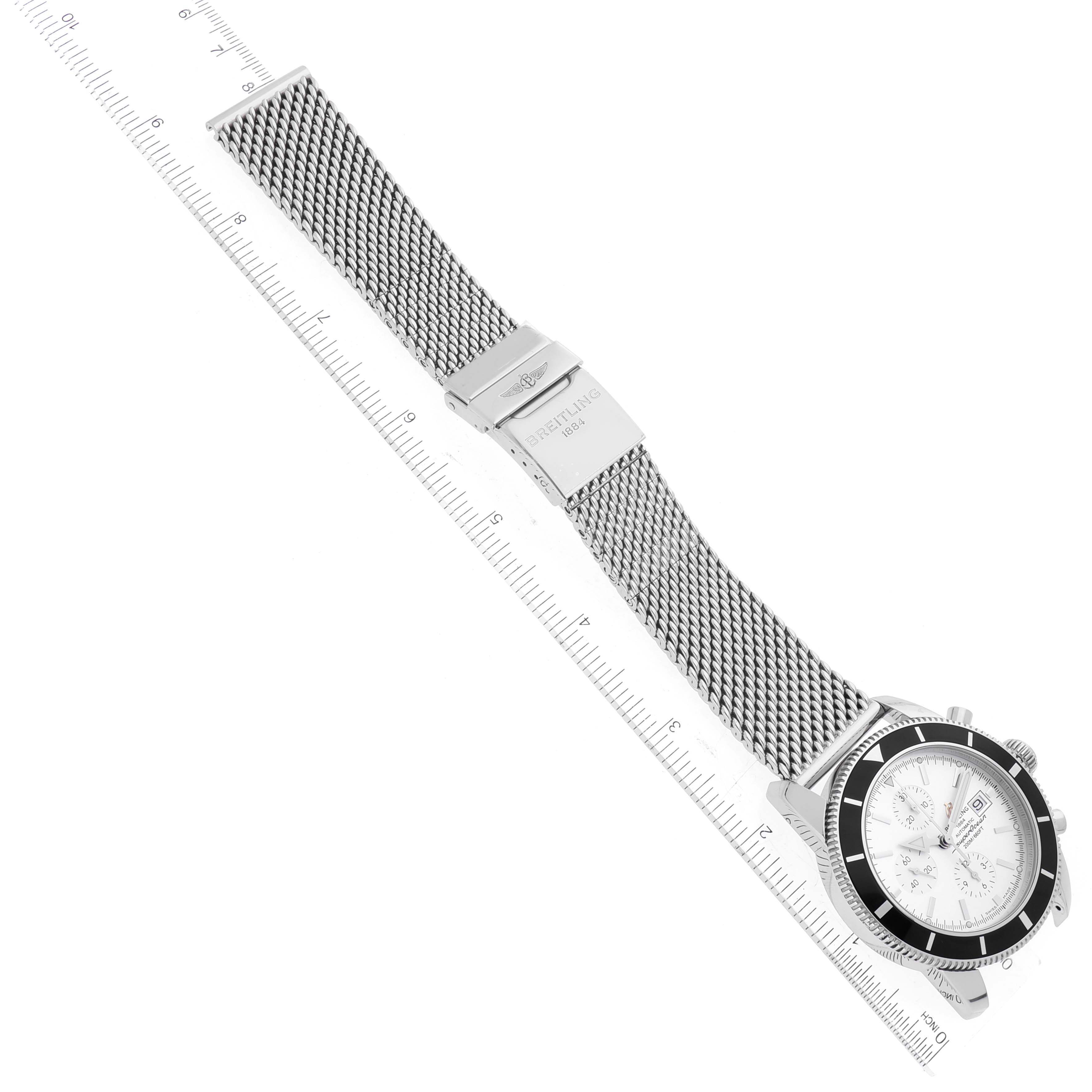 The image shows the Breitling Superocean A13320 Men's Stainless Steel Silver Dial A13320 Men's Stainless Steel Silver Dial watch laid flat with its mesh band extended and a ruler beside it for measurement.
