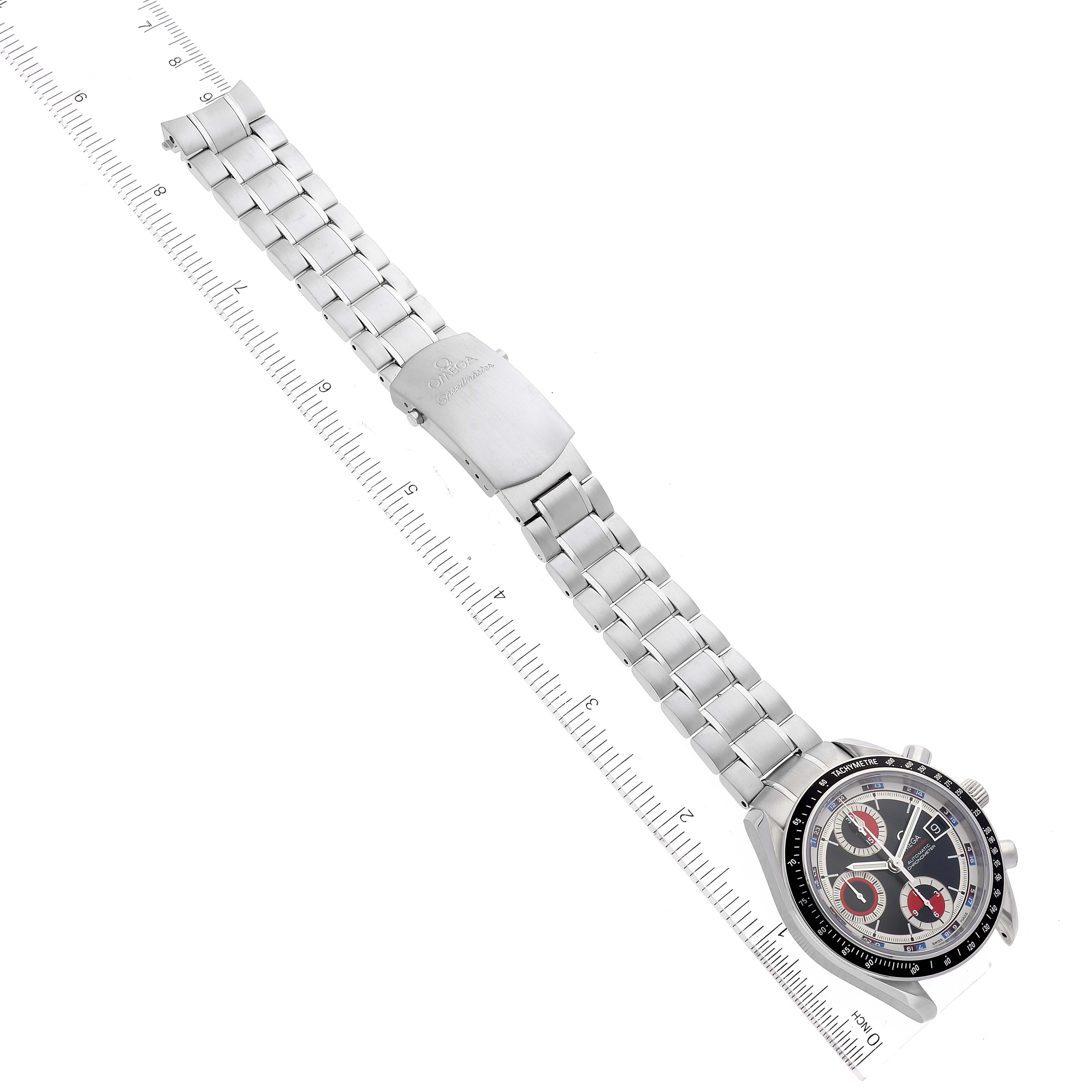 The Omega Speedmaster 3210.52.00 Men
s Stainless Steel Black Dial 3210.52.00 Men
s Stainless Steel Black Dial watch is viewed from above, showing the full bracelet, clasp, and face with a measuring ruler beside it.