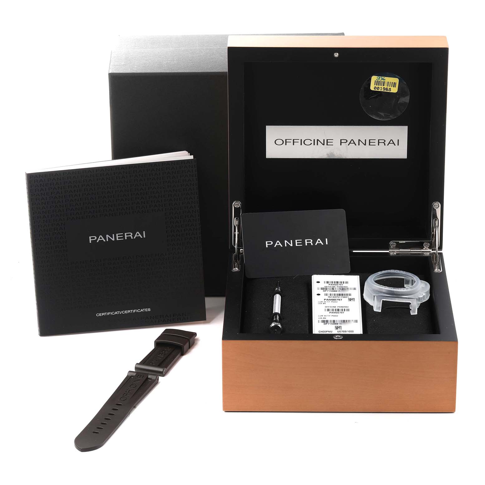 The image shows a Panerai Luminor PAM00797 Men's Titanium Brown Dial PAM00797 Men's Titanium Brown Dial watch box with accessories, including a strap, tool, manuals, and an extra case part, viewed from the front.
