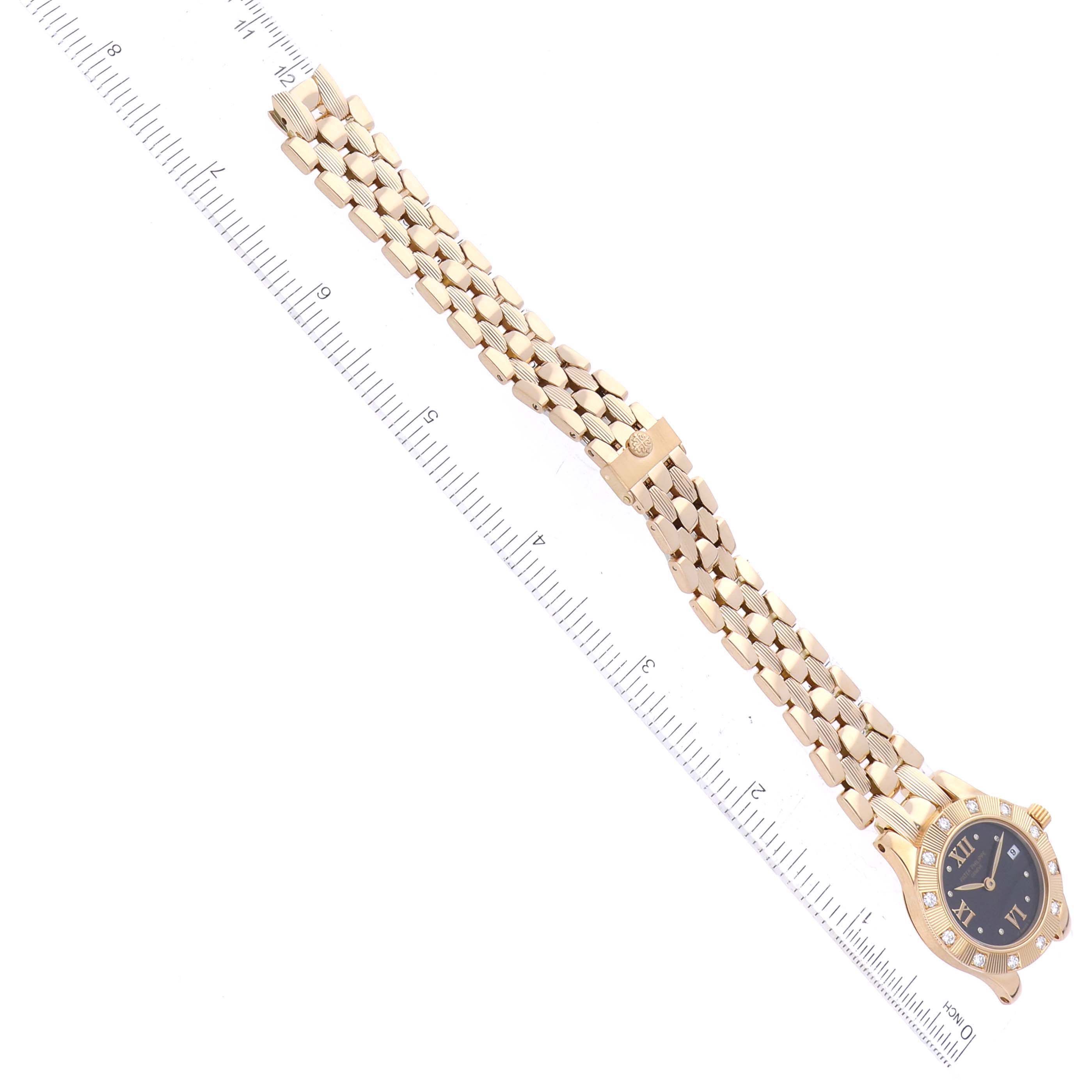 The image shows a Patek Philippe Neptune 4881 Women's Yellow Gold Black Dial 4881 Women's Yellow Gold Black Dial watch laid flat, facing upwards, with a ruler indicating its length.