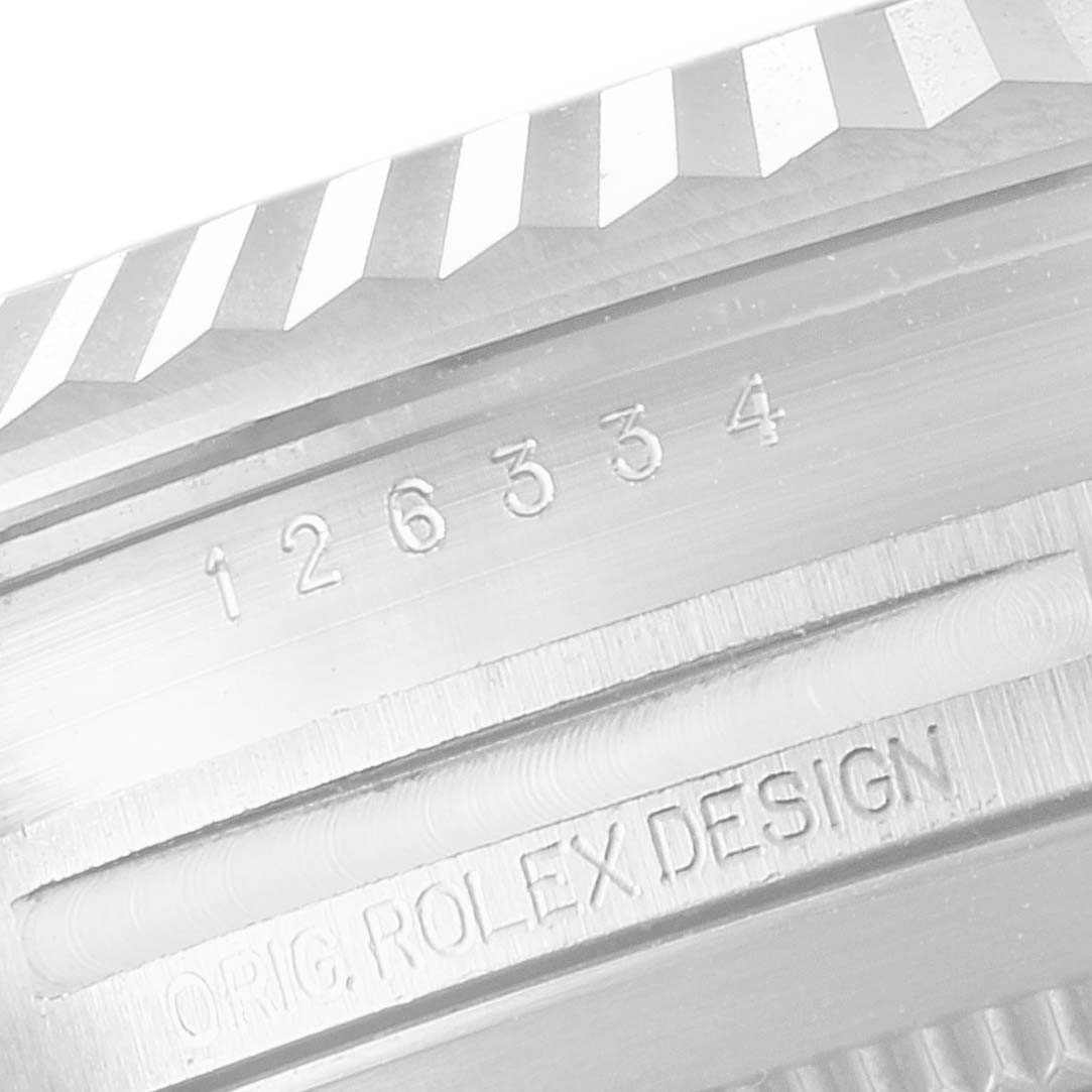 This close-up image shows the serial number engraving and part of the fluted bezel of a Rolex Datejust 41 126334 Men
s Stainless Steel Black Dial 126334 Men
s Stainless Steel Black Dial watch.