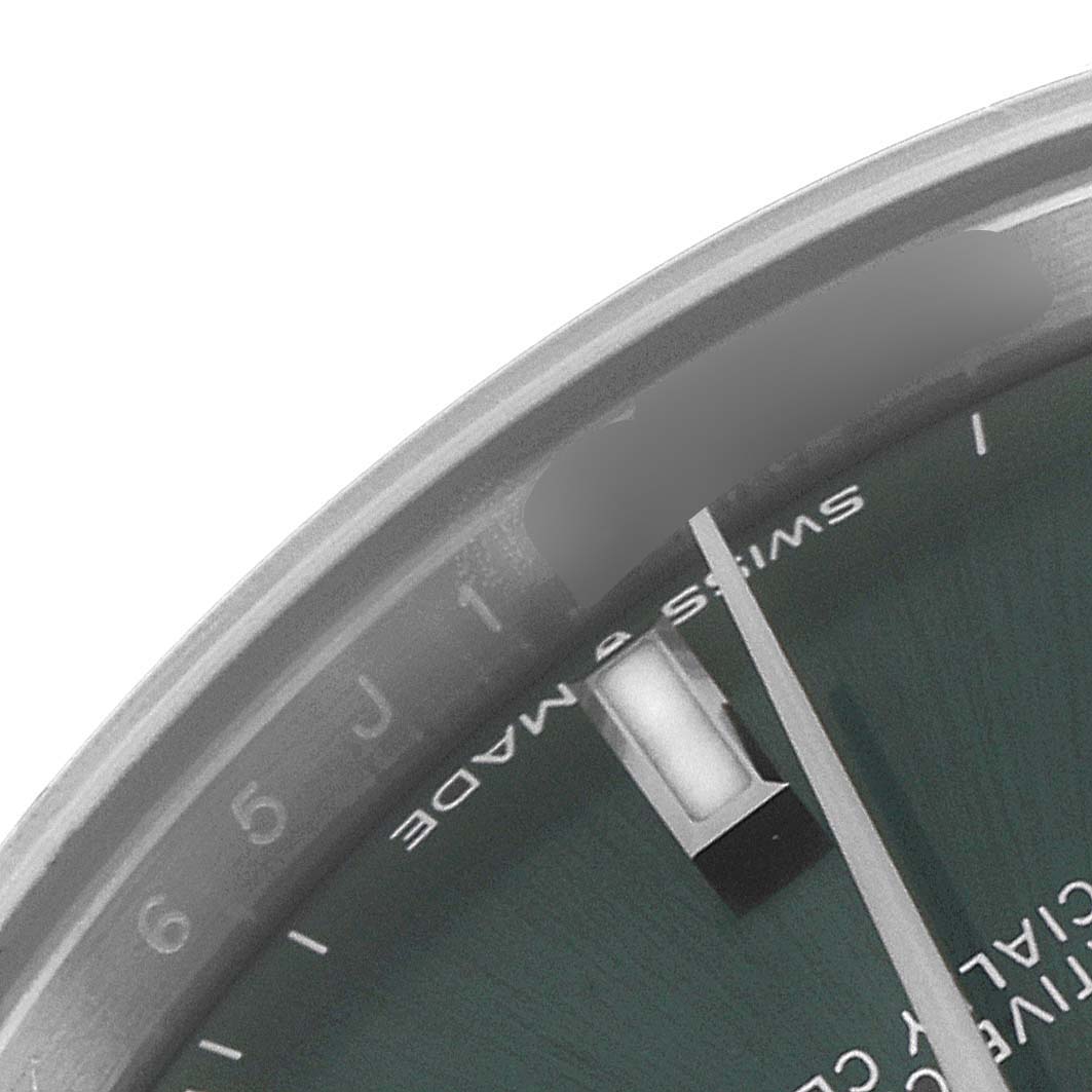 This is a close-up view of the dial and part of the bezel of a Rolex Mid-Size 278274 Women's Stainless Steel Green Dial 278274 Women's Stainless Steel Green Dial model watch, showing the hour markers and text "SWISS MADE."