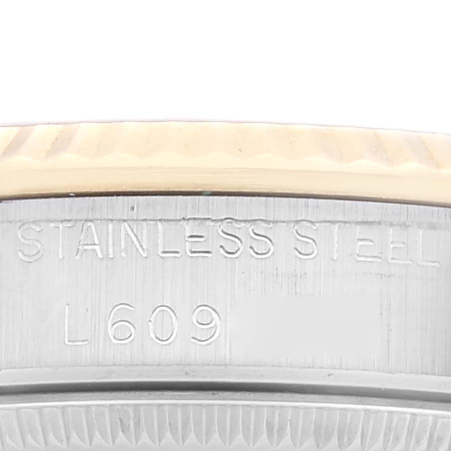 This image of the Rolex Mid-Size 68273 Women's Stainless Steel Champagne Dial 68273 Women's Stainless Steel Champagne Dial watch shows a close-up of the stainless steel case with an engraved serial number.