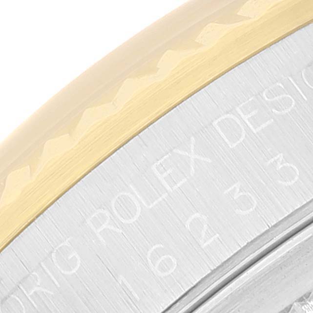 The image shows a close-up angle of the Rolex Datejust 16233 Men's Steel and Gold (two tone) Champagne Dial 16233 Men's Steel and Gold (two tone) Champagne Dial model, focusing on the engraved bezel and part of the casing.