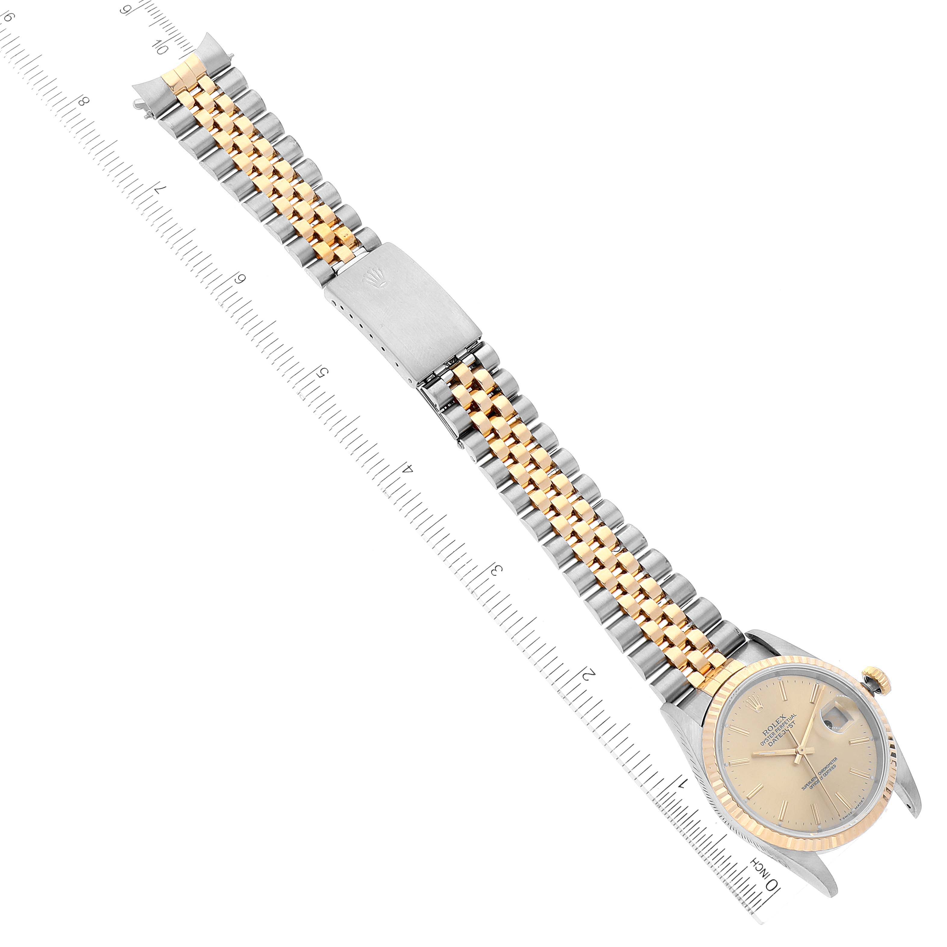 The image shows a full view of the Rolex Datejust 16233 Men's Steel and Gold (two tone) Champagne Dial 16233 Men's Steel and Gold (two tone) Champagne Dial watch, including its face, bezel, crown, and jubilee bracelet, aligned with a ruler.