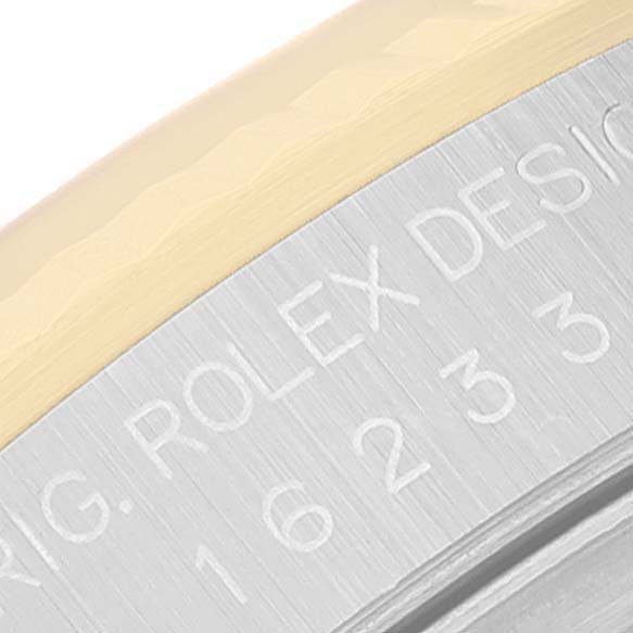 This image shows a macro shot of the edge of a Rolex Datejust 16233 Men's Steel and Gold (two tone) Silver Dial 16233 Men's Steel and Gold (two tone) Silver Dial watch case with engraved text.